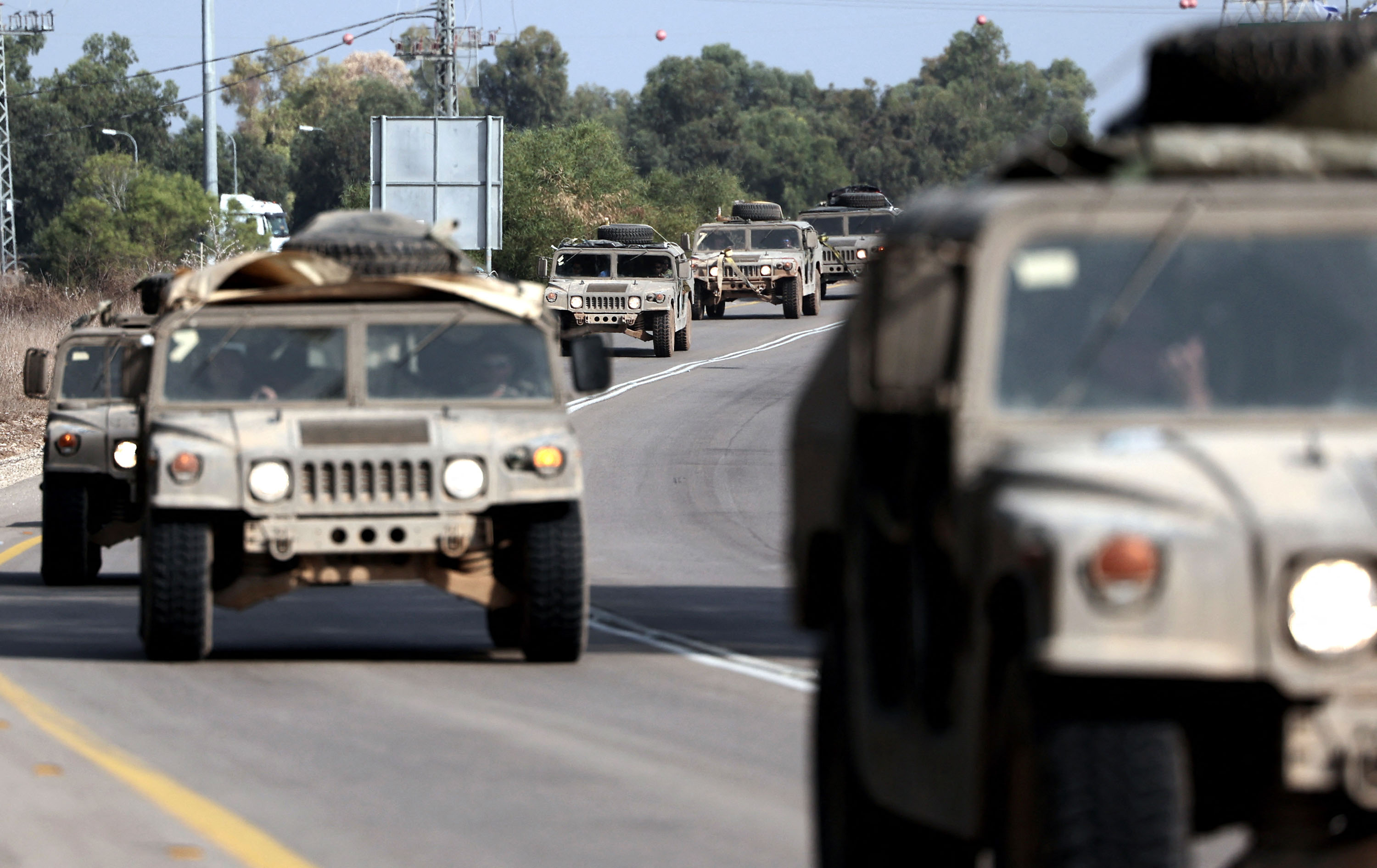 A convoy of Israeli army vehicles drives along a road close to the southern Israeli city of Sderot on October 23.