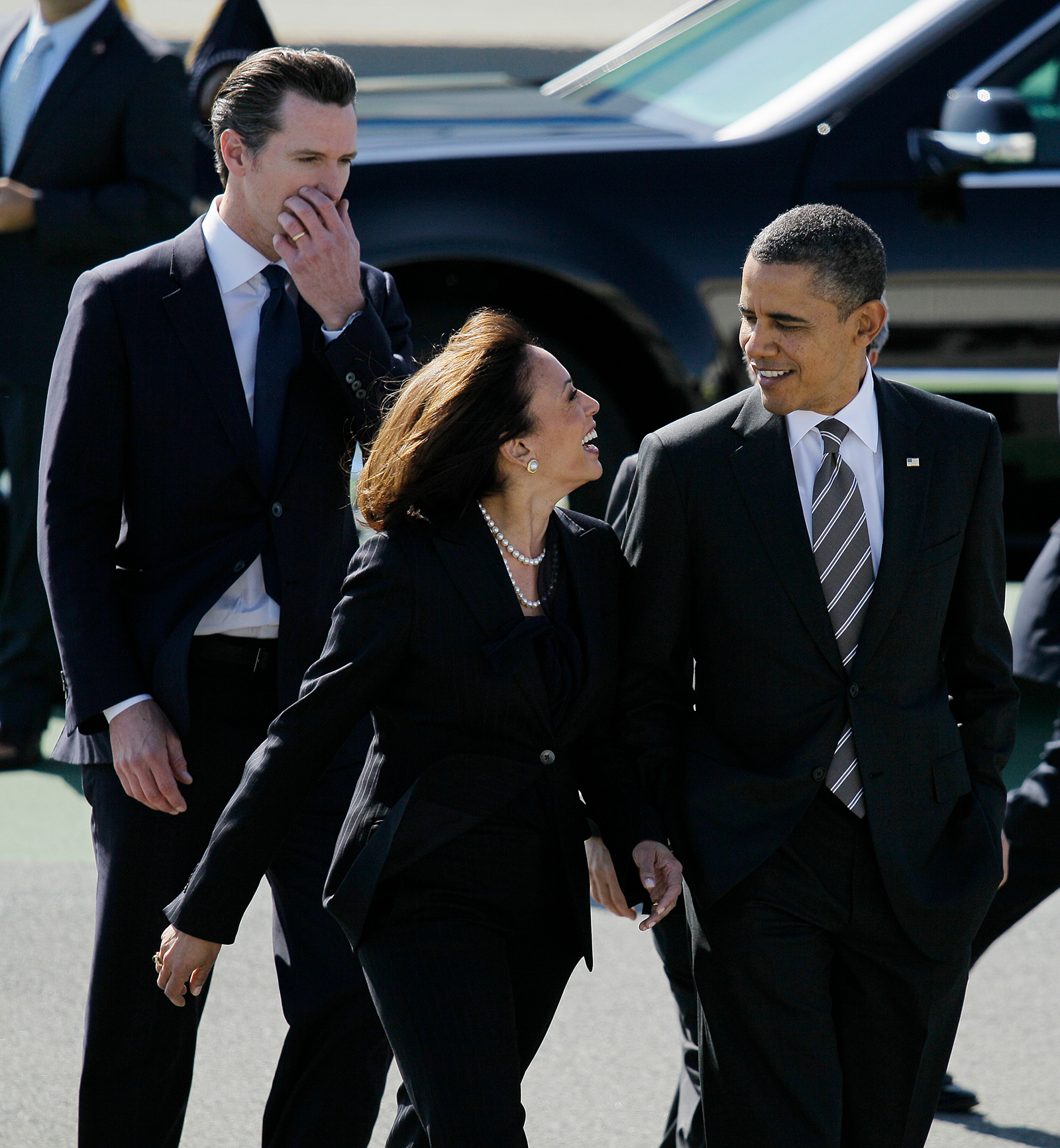 President Barack Obama walks with California Attorney General Kamala Harris, center, and California Lt. Gov. Gavin Newsom, after arriving at San Francisco International Airport in San Francisco, Thursday, February 16, 2012.