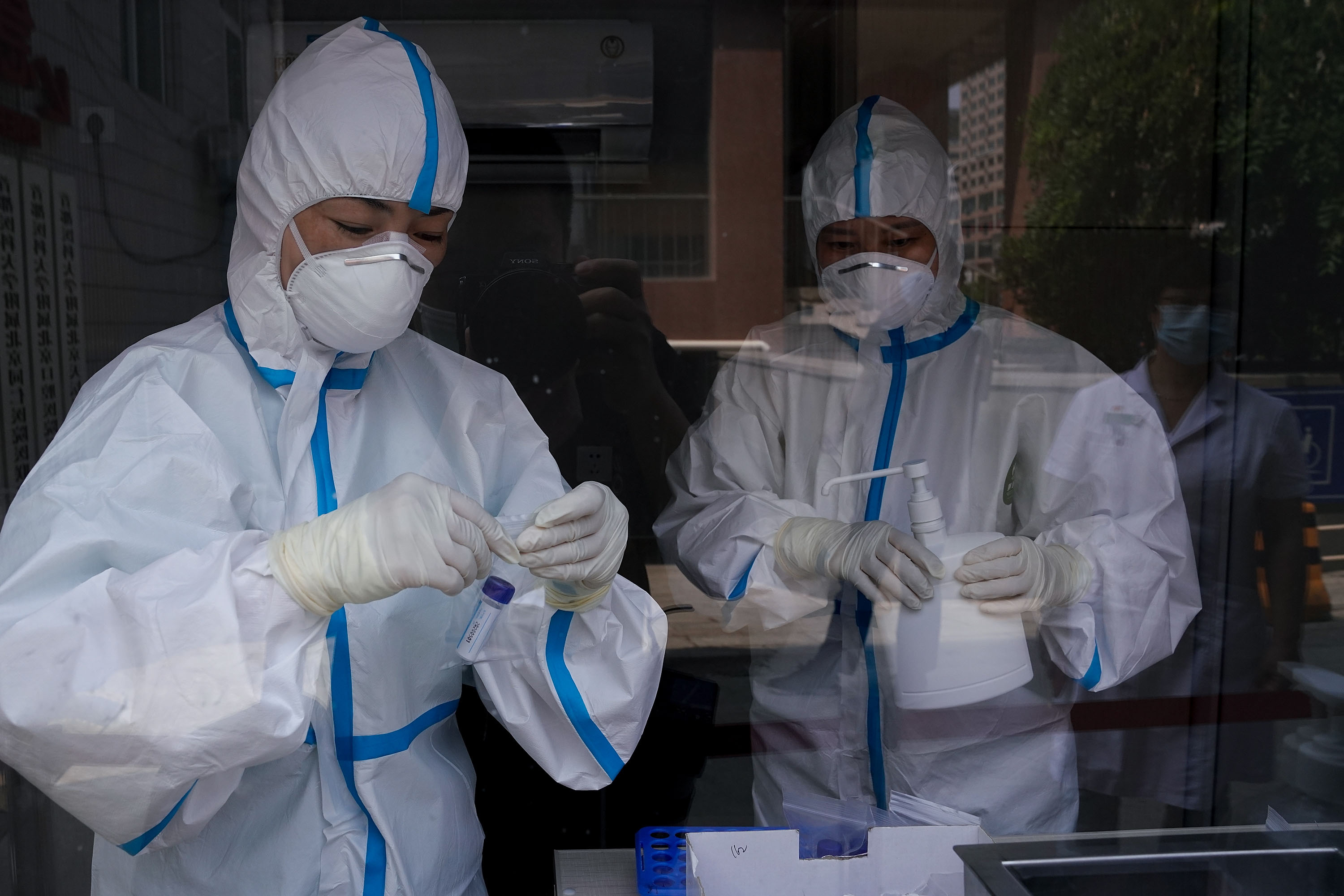 Medical workers check samples at a Beijing hospital testing station on July 14.