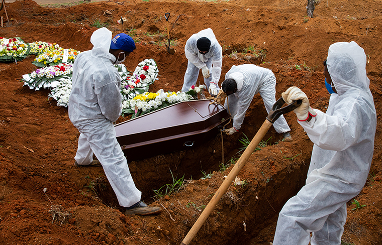 Cemetery workers in protective suits bury a victim of coronavirus at the Vila Formosa cemetery on Thursday, July 16, in Sao Paulo, Brazil.