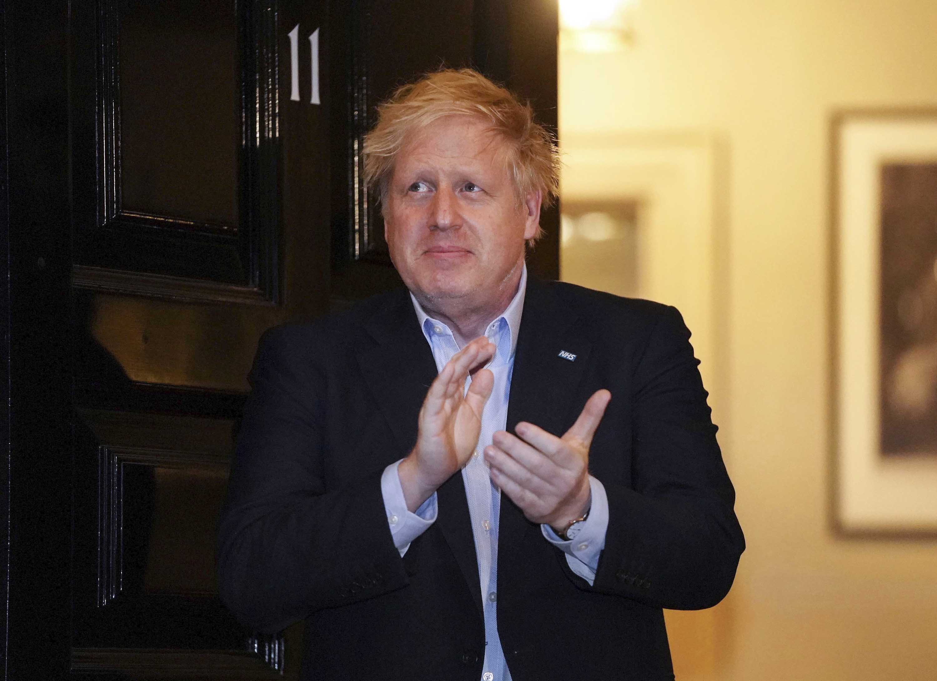 British Prime Minister Boris Johnson claps outside Downing Street in London on April 2, during a nationwide "Clap for Carers" NHS initiative to applaud workers fighting the coronavirus pandemic.