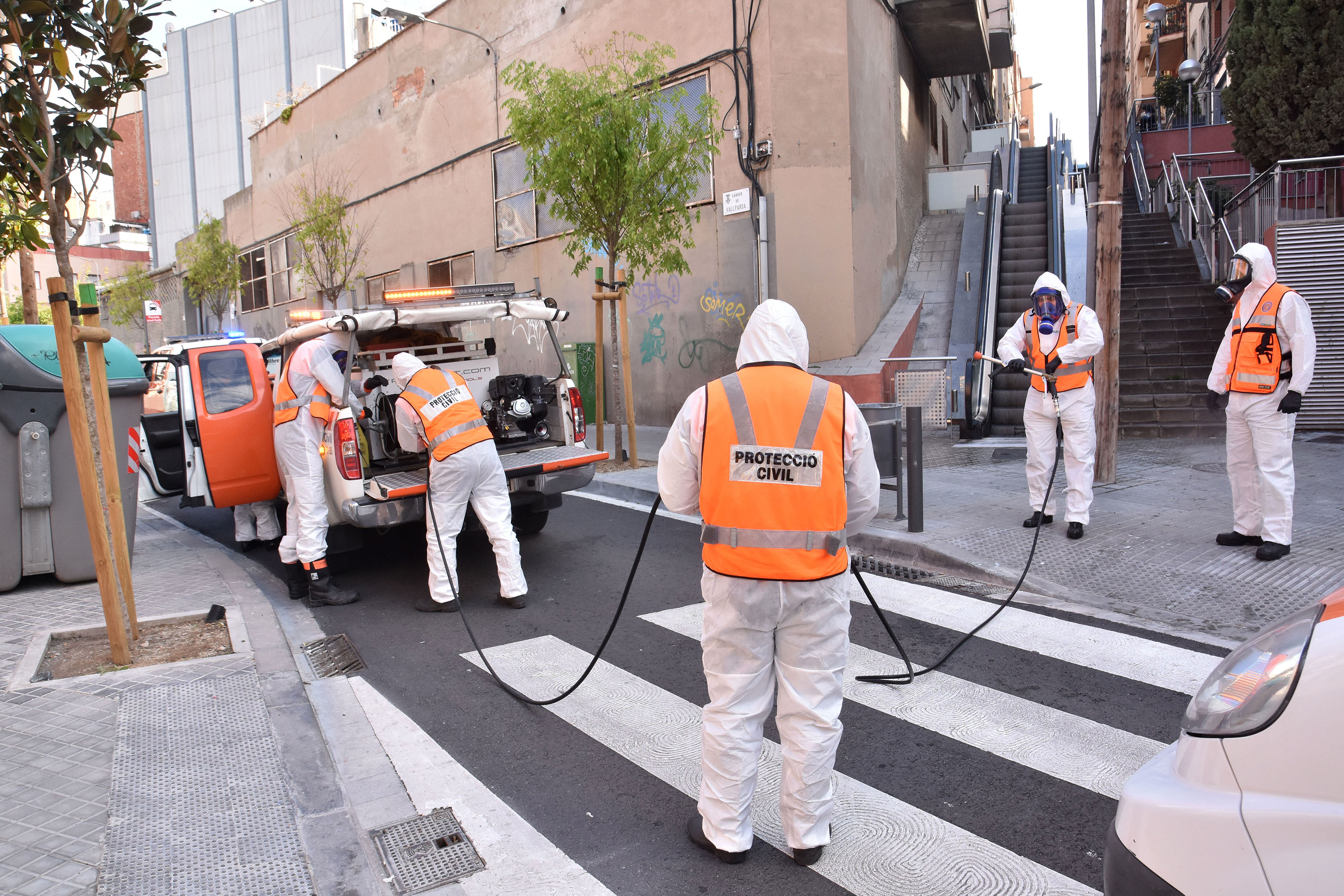 A group of civil protection volunteers from disinfects a street in L´Hospitalet, Spain, on March 27.