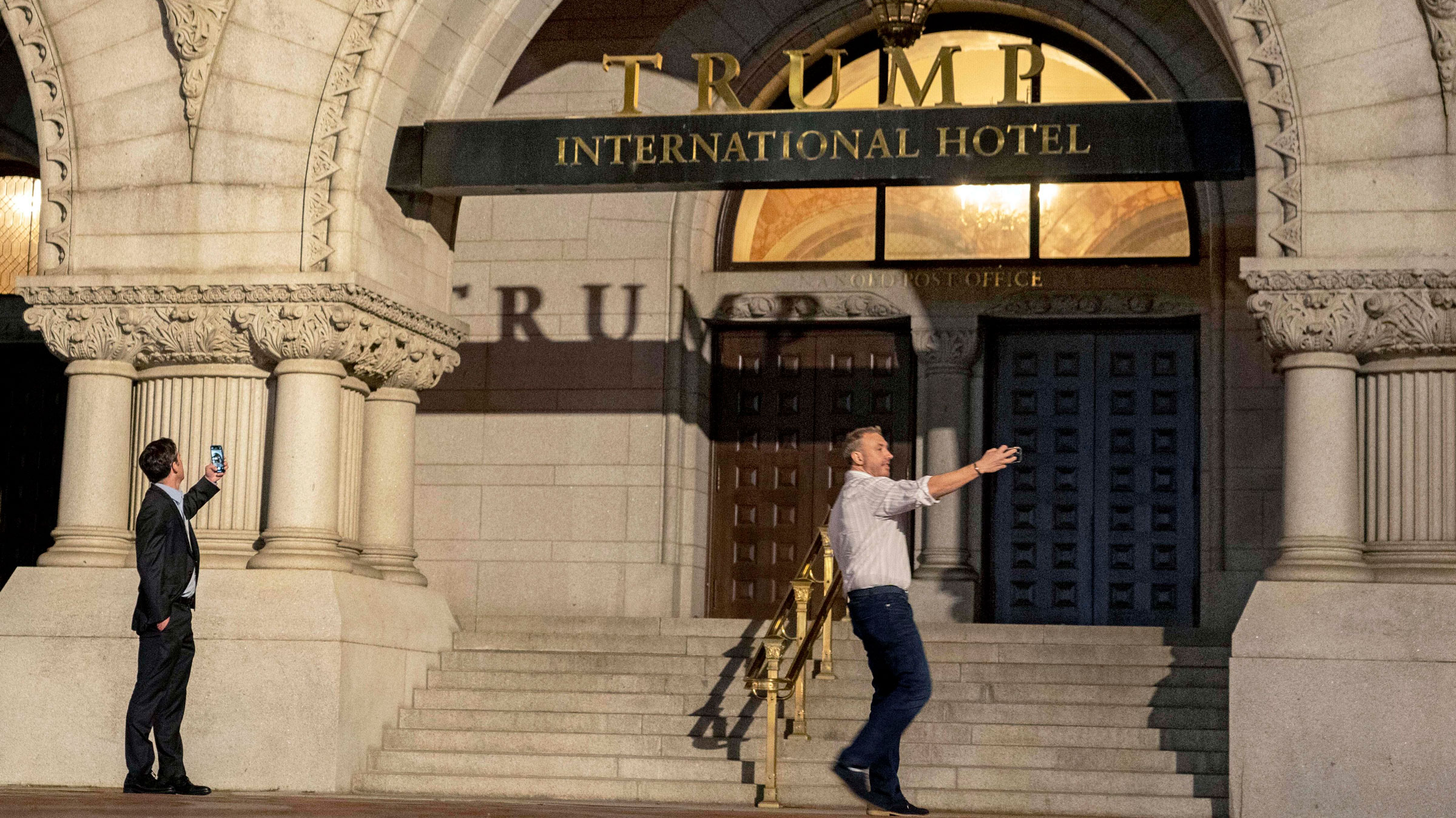 People photograph the outside of the Trump International Hotel in Washington, DC, in May.