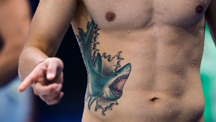 Nadadora olímpica com uma impressionante tatuagem de tubarão azul brilhante no peito durante uma sessão de treinamento no Centro Aquático de Tóquio para a competição de natação no domingo, 25 de julho de 2021, em Tóquio, Japão.