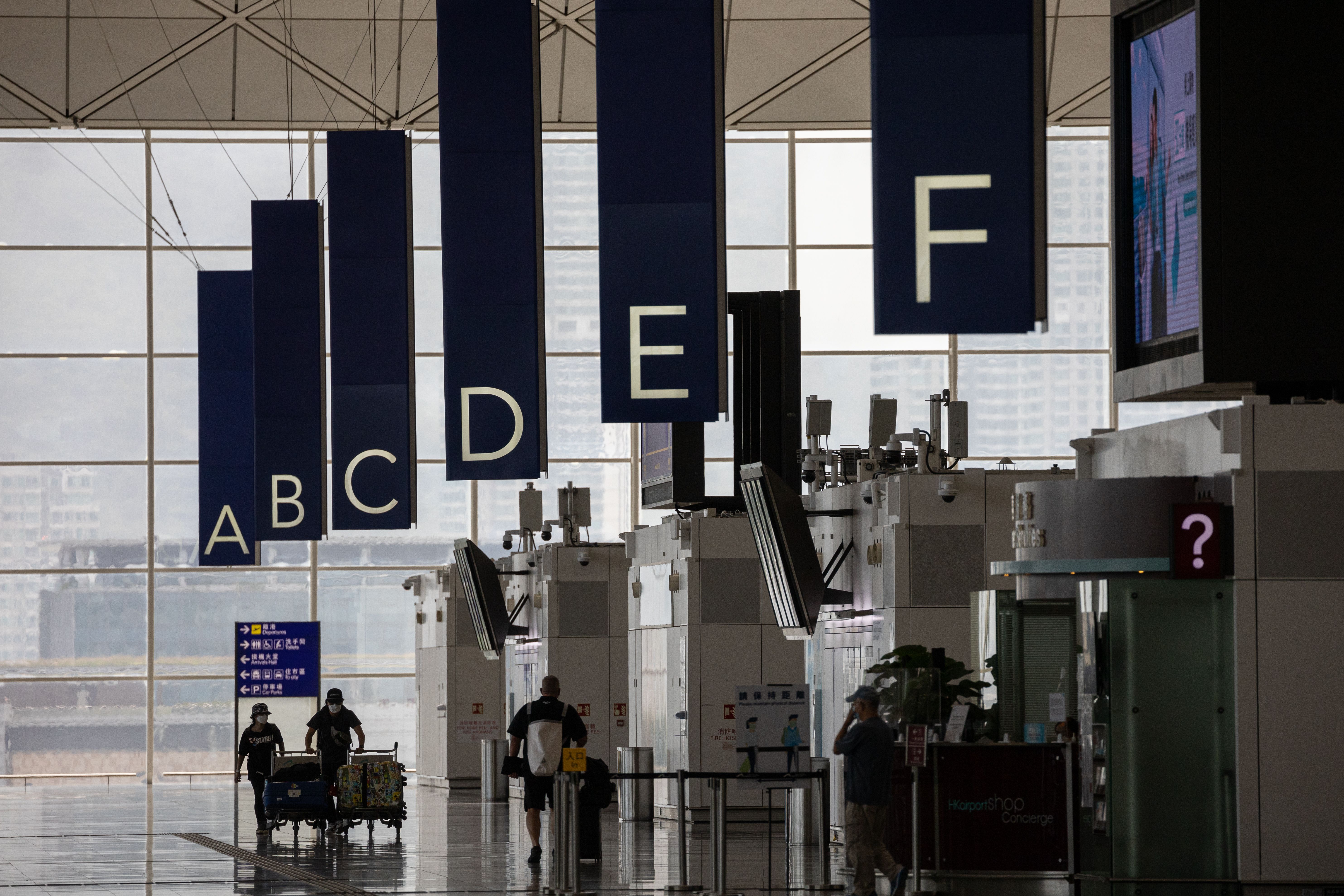 Travelers push their bags into the departure lounge at Hong Kong International Airport on October 19.