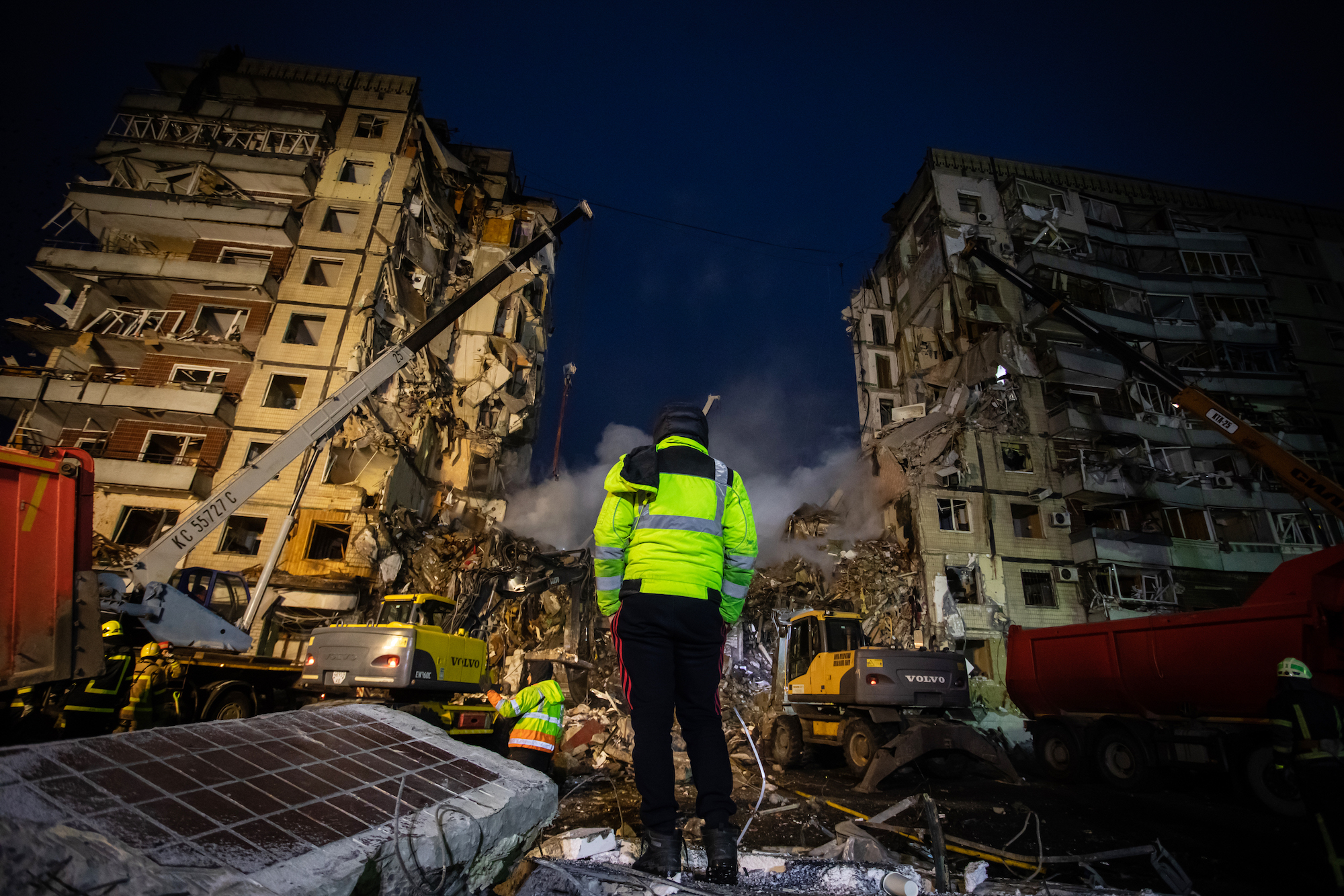 An emergency worker views the site of a residential building hit by a Russian missile on Sunday in Dnipro. 