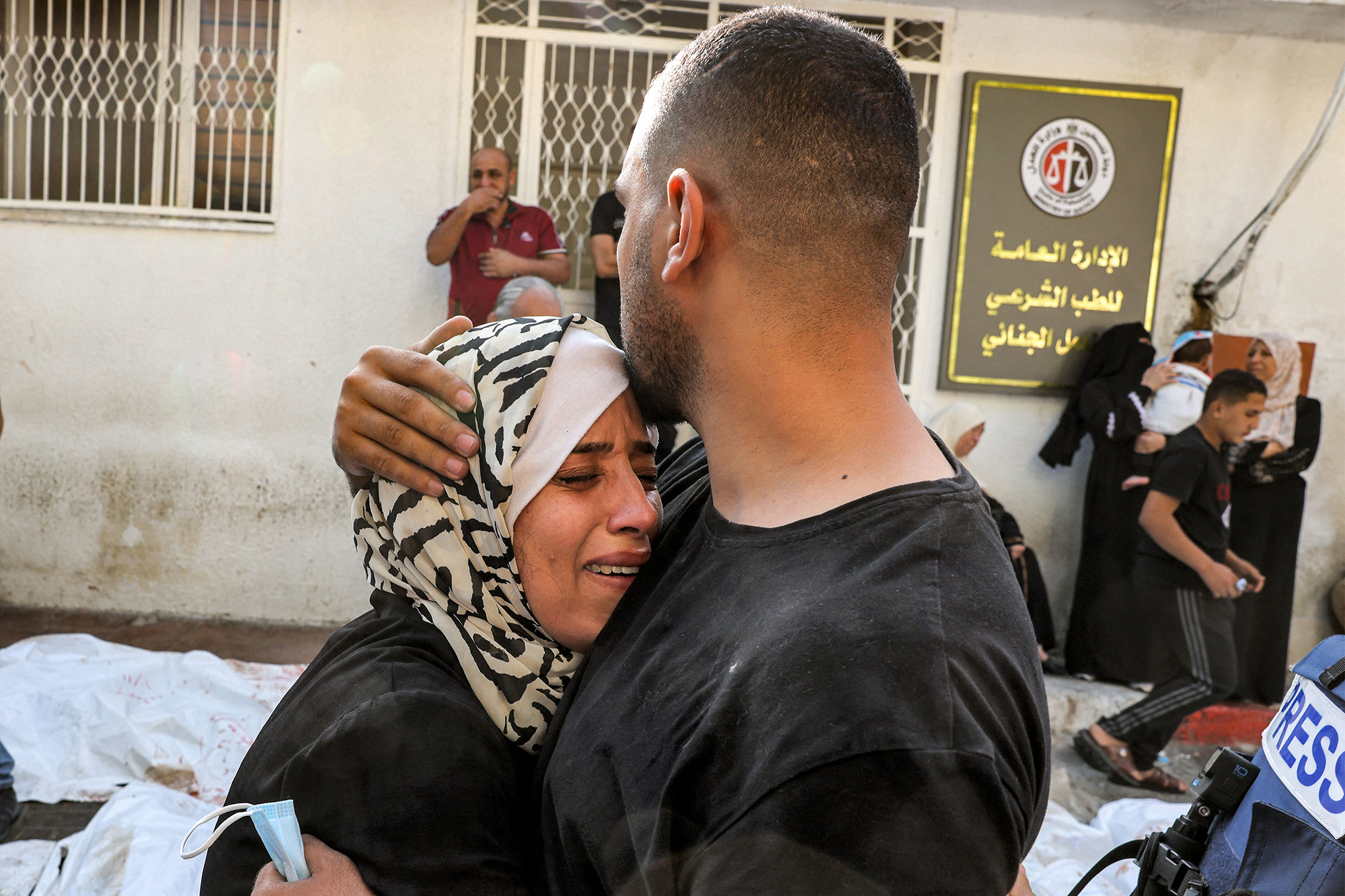 A man comforts a woman mourning outside the morgue of al-Shifa hospital in Gaza City, Gaza, on October 12.