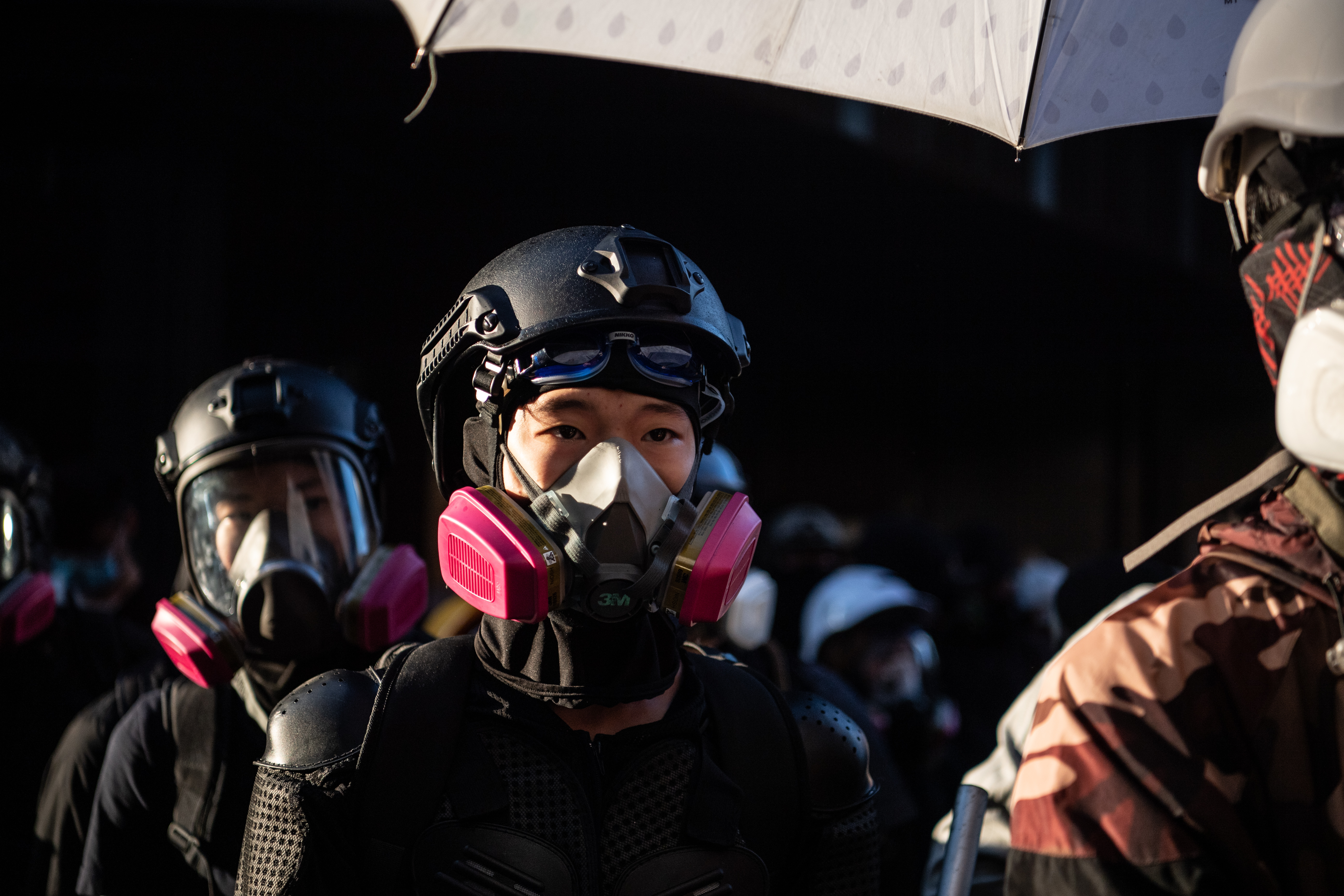 Anti-government protesters stand during a lull in the middle of clashes with police at Hong Kong Polytechnic University on November 18.