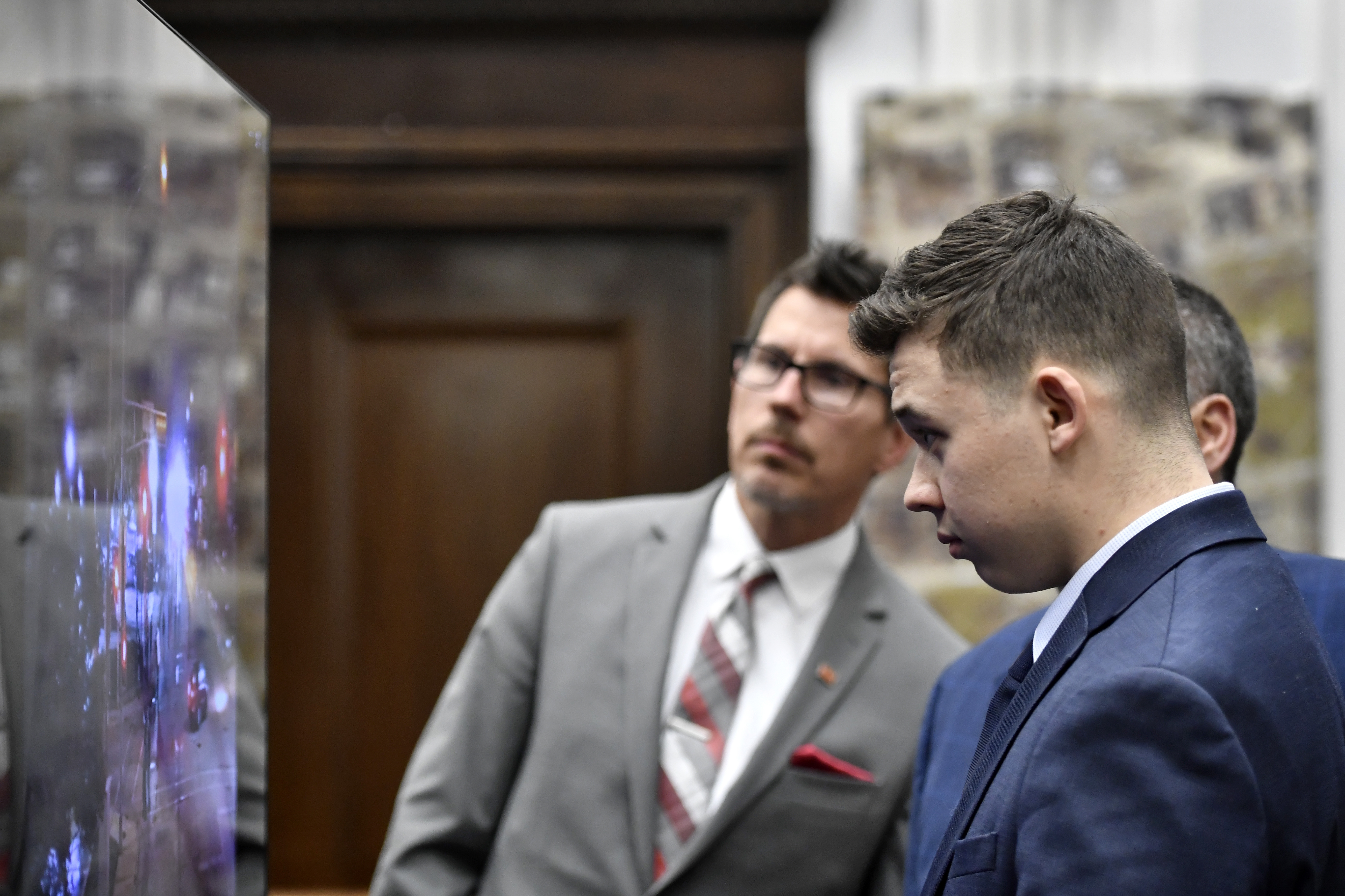 Kyle Rittenhouse, right, watch an aerial video of the moments where he shot Jospeh Rosenbaum on Aug. 25, 2020, during his trail at the Kenosha County Courthouse on Wednesday.
