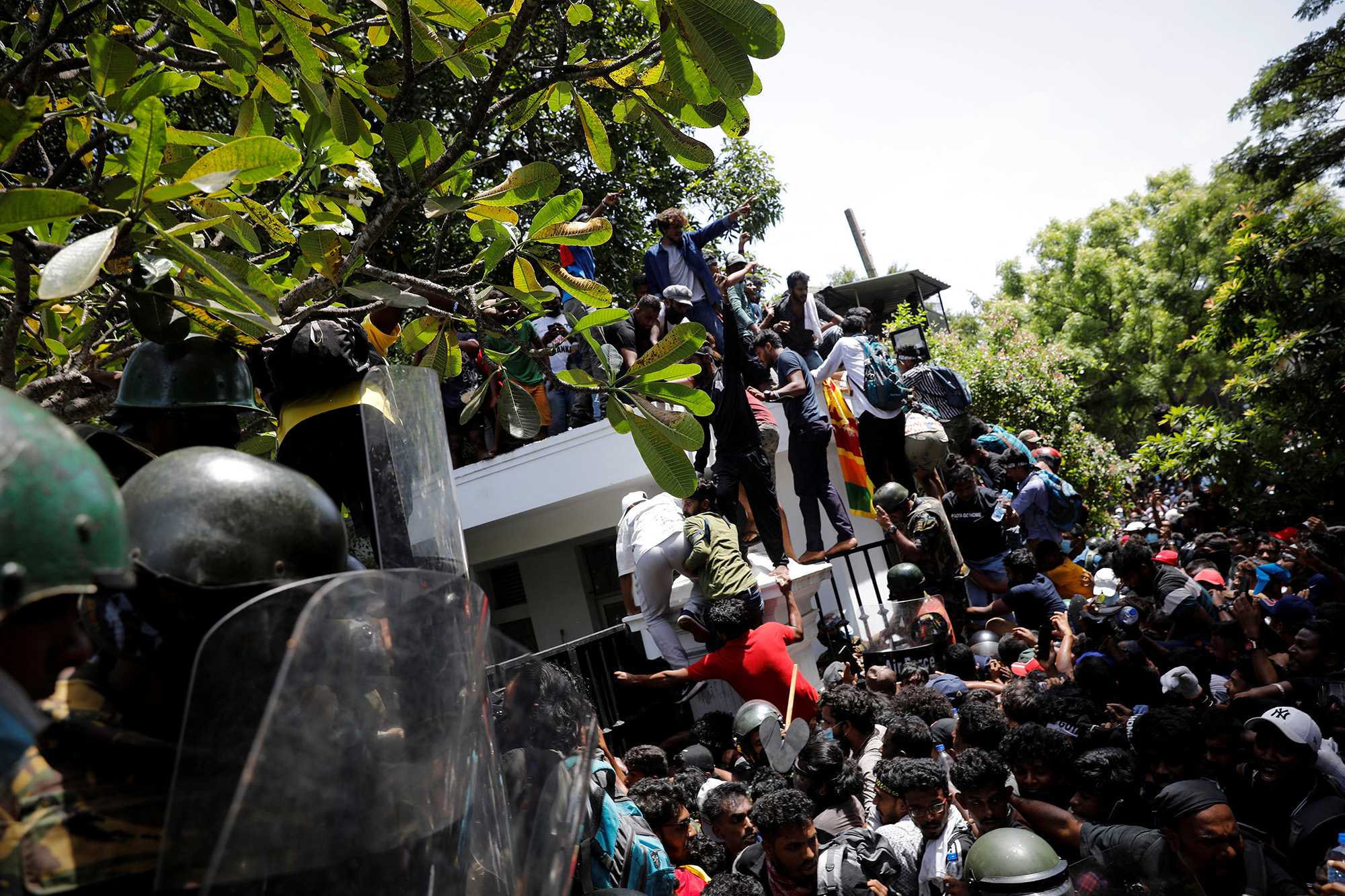Protestors climb the front gate of Sri Lanka's Prime Minister Ranil Wickremesinghe's office during a protest in Colombo, Sri Lanka, on July 13.