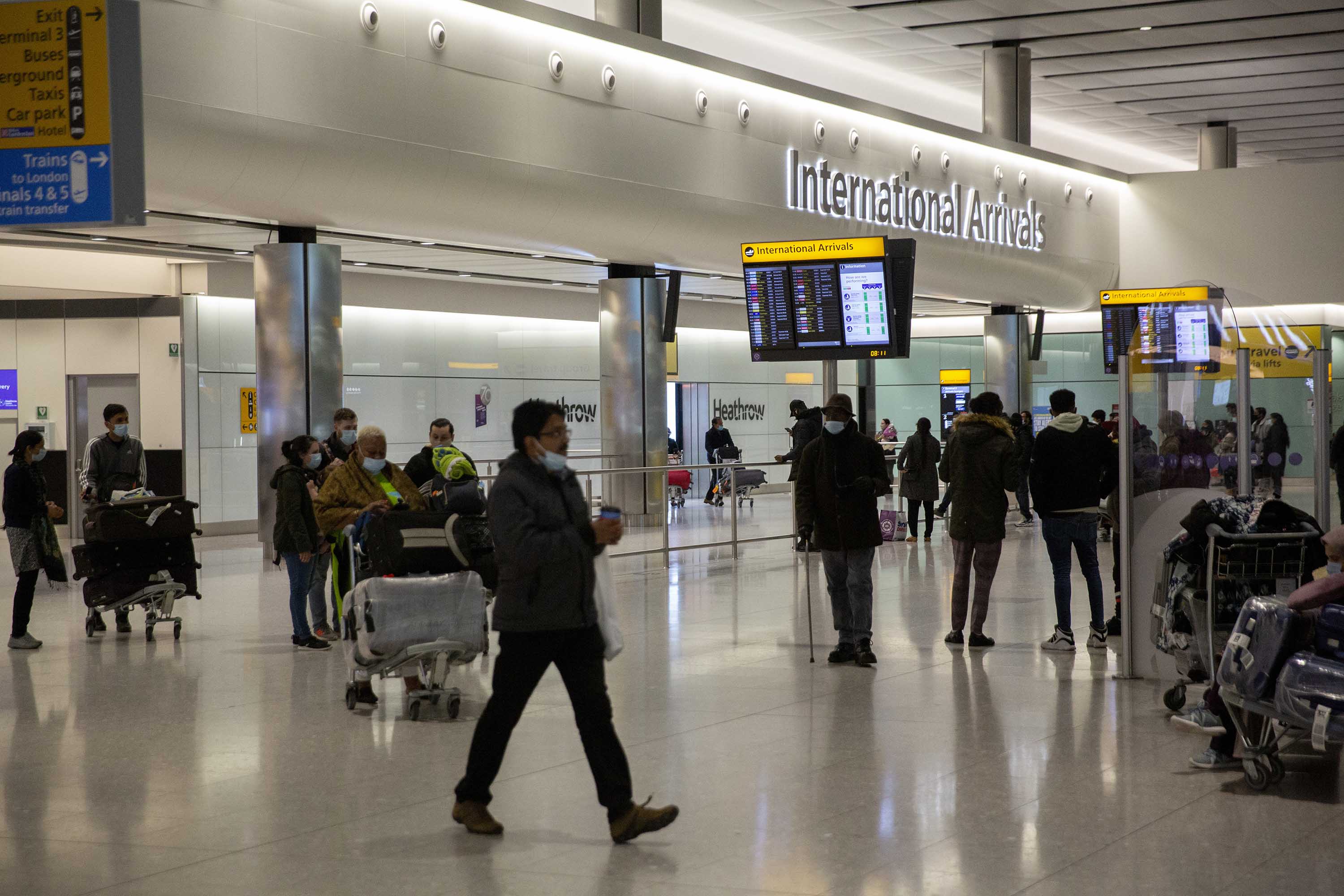 People pass through the international arrivals area at Heathrow Airport in London, on January 26. 