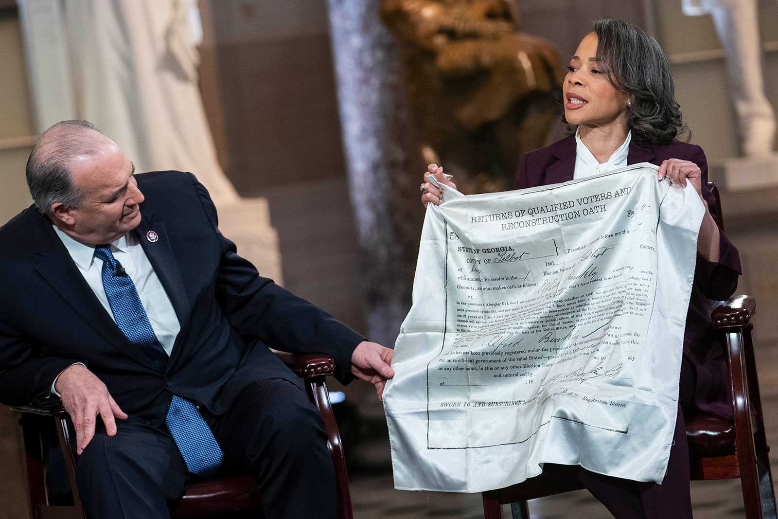 Democratic Rep. Lisa Blunt Rochester displays a scarf featuring the voting card that belonged to her "great-great-great-grandfather" who was enslaved. 