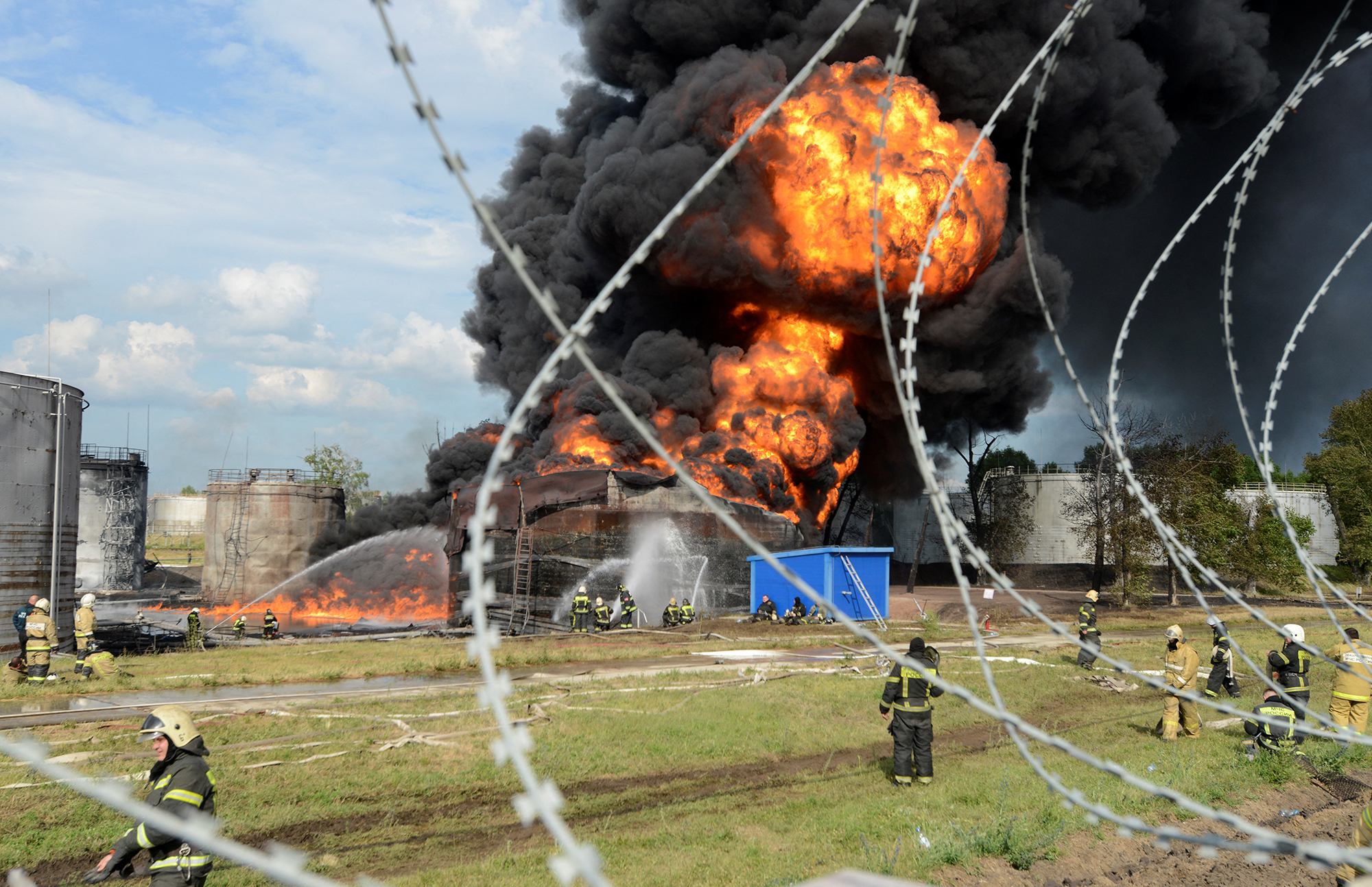 Emergency responders work to extinguish a burning fuel tank at an oil refinery in Voronezh, Russia, on June 24. 