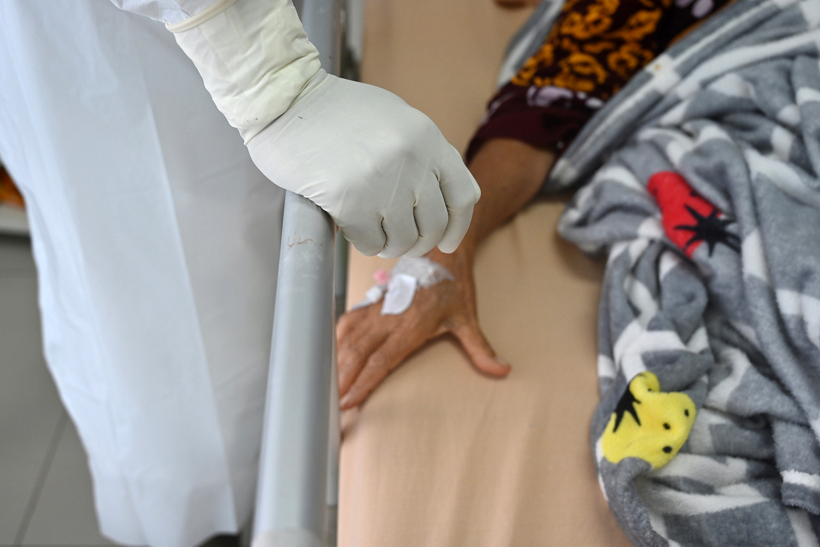 La mano de un médico se encuentra junto a la de un paciente de Kovit-19 el 25 de enero en un hospital público en Bogor, Indonesia.