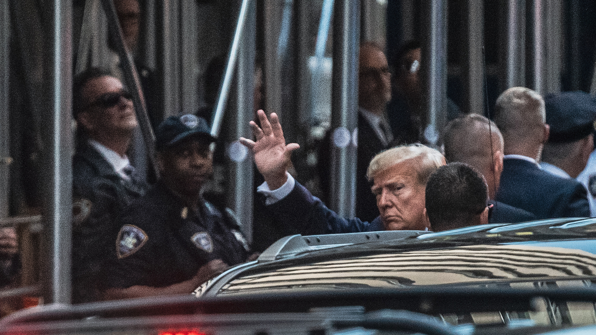 Former President Donald Trump waves as he steps out of his vehicle before entering New York Criminal Court on Tuesday.