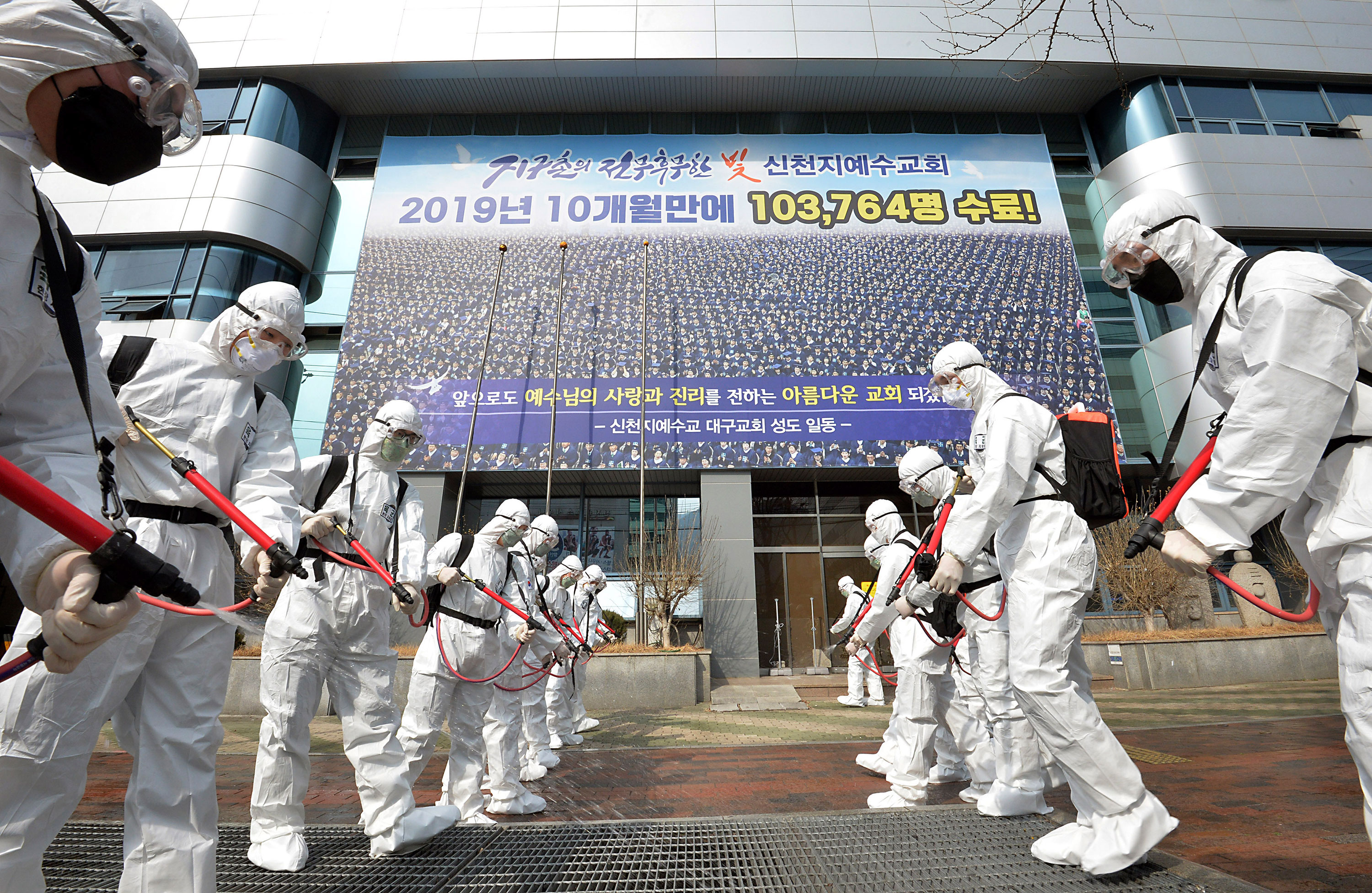 Workers spray disinfectant in front of a branch of the Shincheonji Church of Jesus in Daegu, South Korea, on March 1.