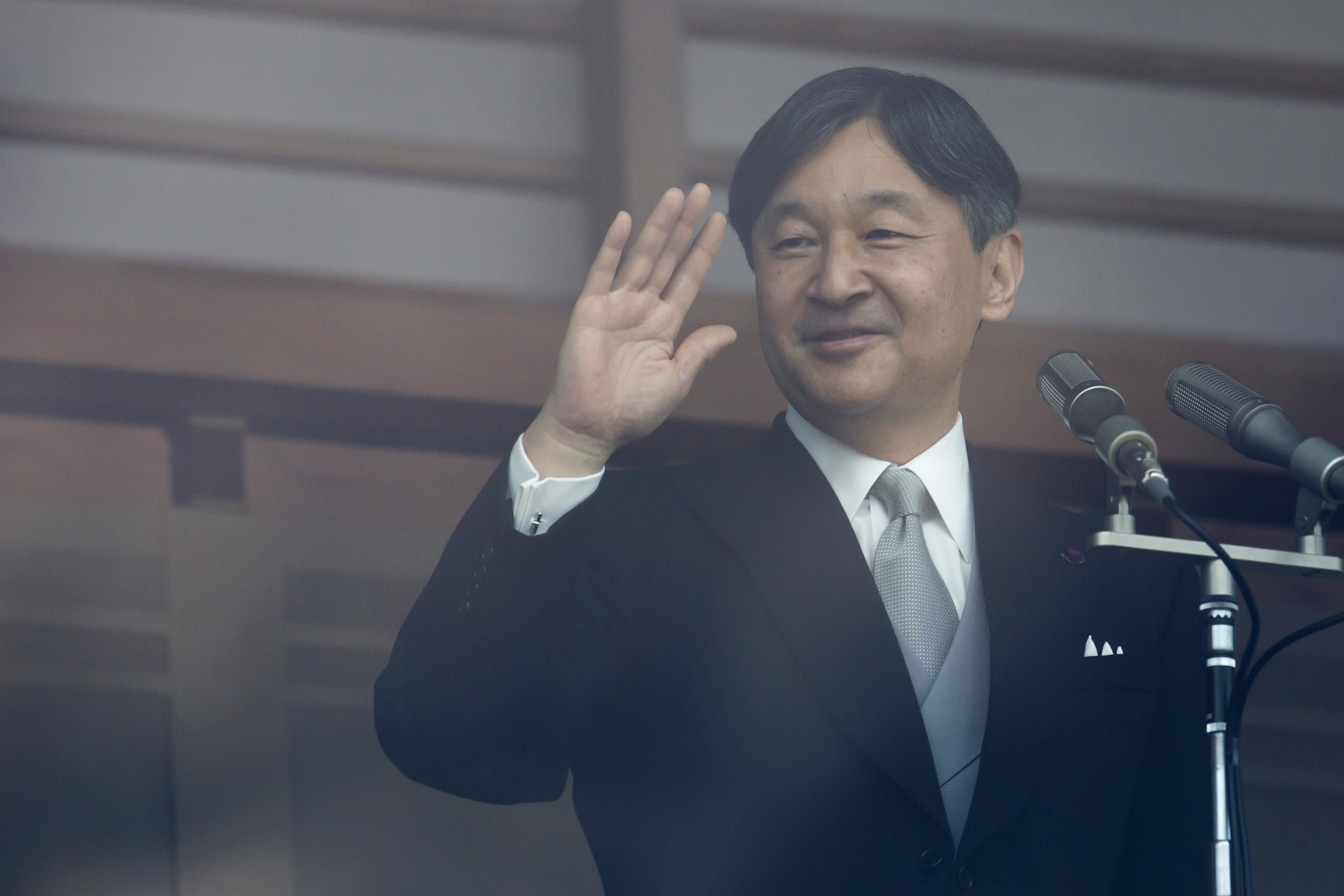 Japan's Emperor Naruhito waves to members of the public on May 4 