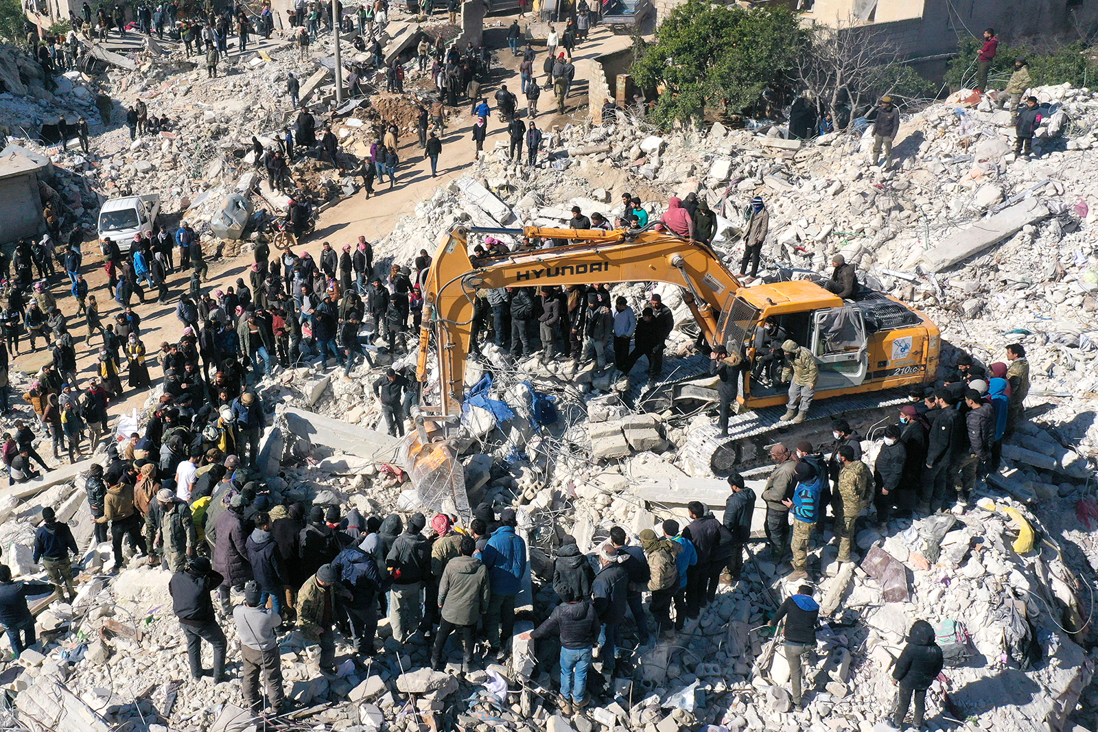 This aerial view shows rescuers searching for survivors amidst the rubble of a collapsed building in the town of Harim, Syria, on the border with Turkey, on February 8.