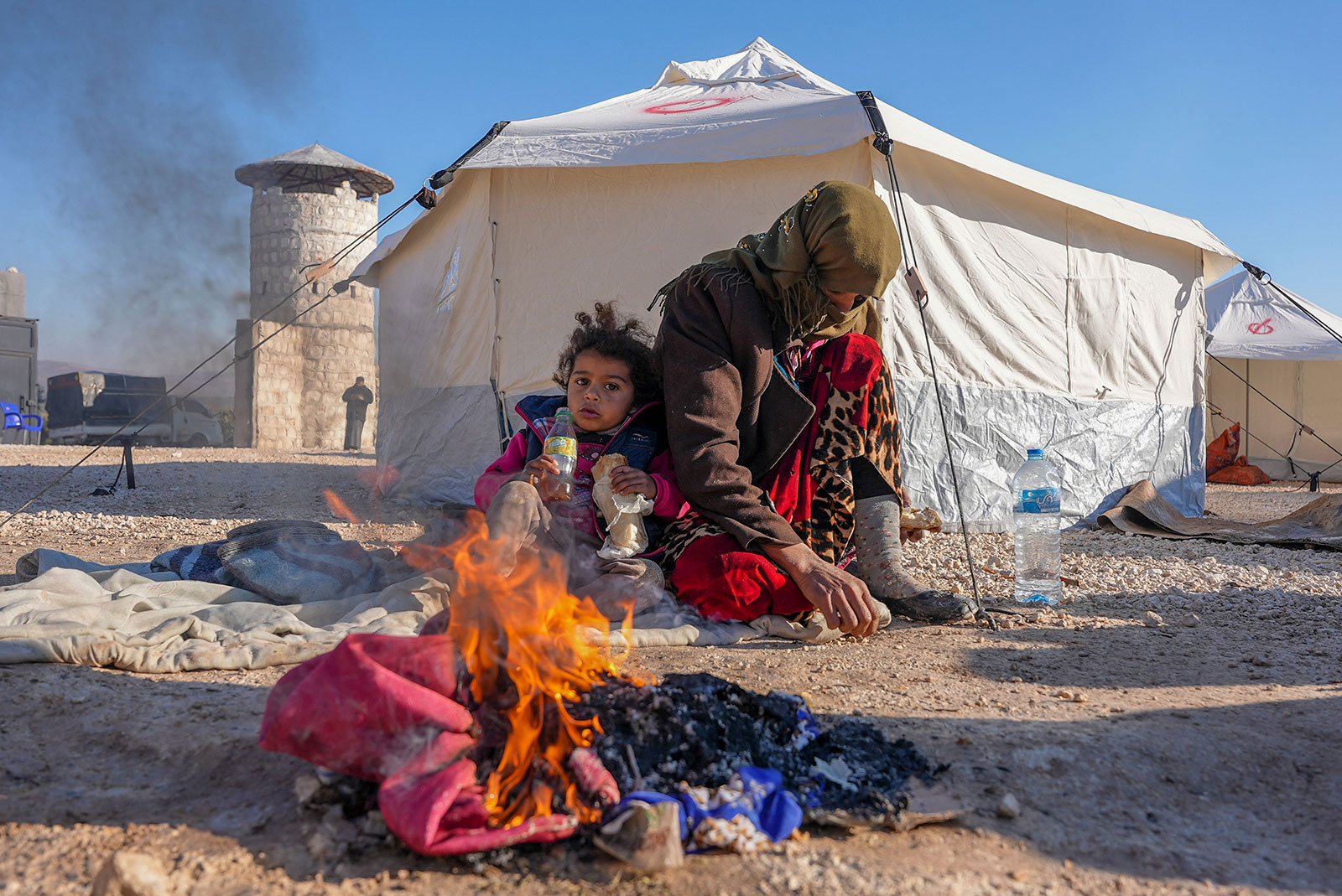 Syrians warm up by a fire at a make-shift shelter for people who were left homeless near the rebel-held town of Jindayris on February 9.
