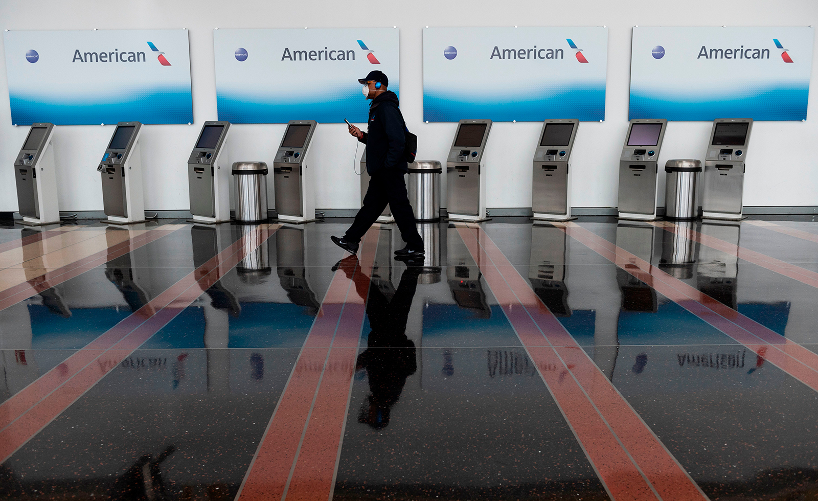 A passenger walks past empty American Airlines check-in terminals at Ronald Reagan Washington National Airport in Arlington, Virginia, on May 12.