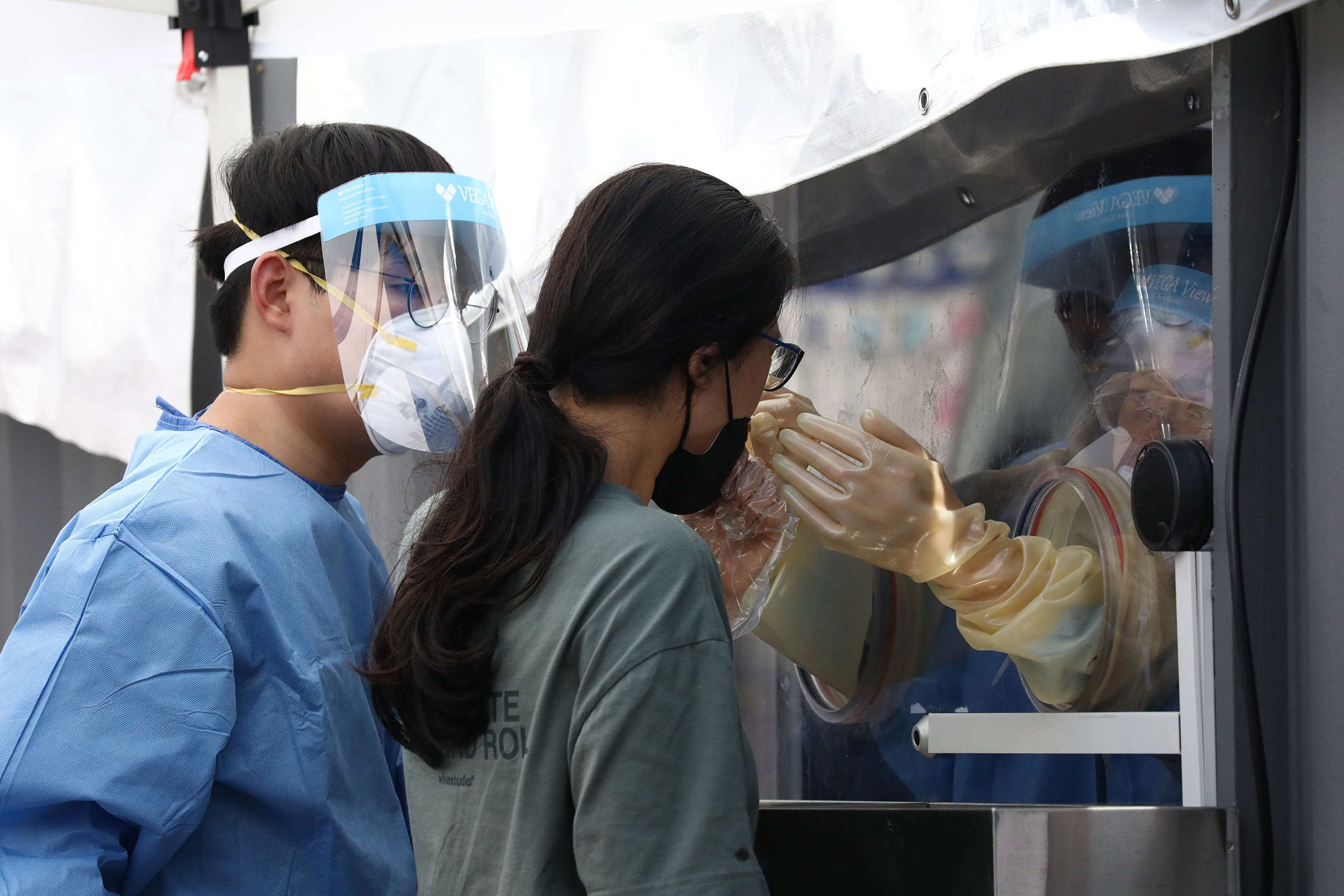A medical worker takes samples from a woman during Covid-19 testing at a temporary test facility on August 26, in Seoul. 