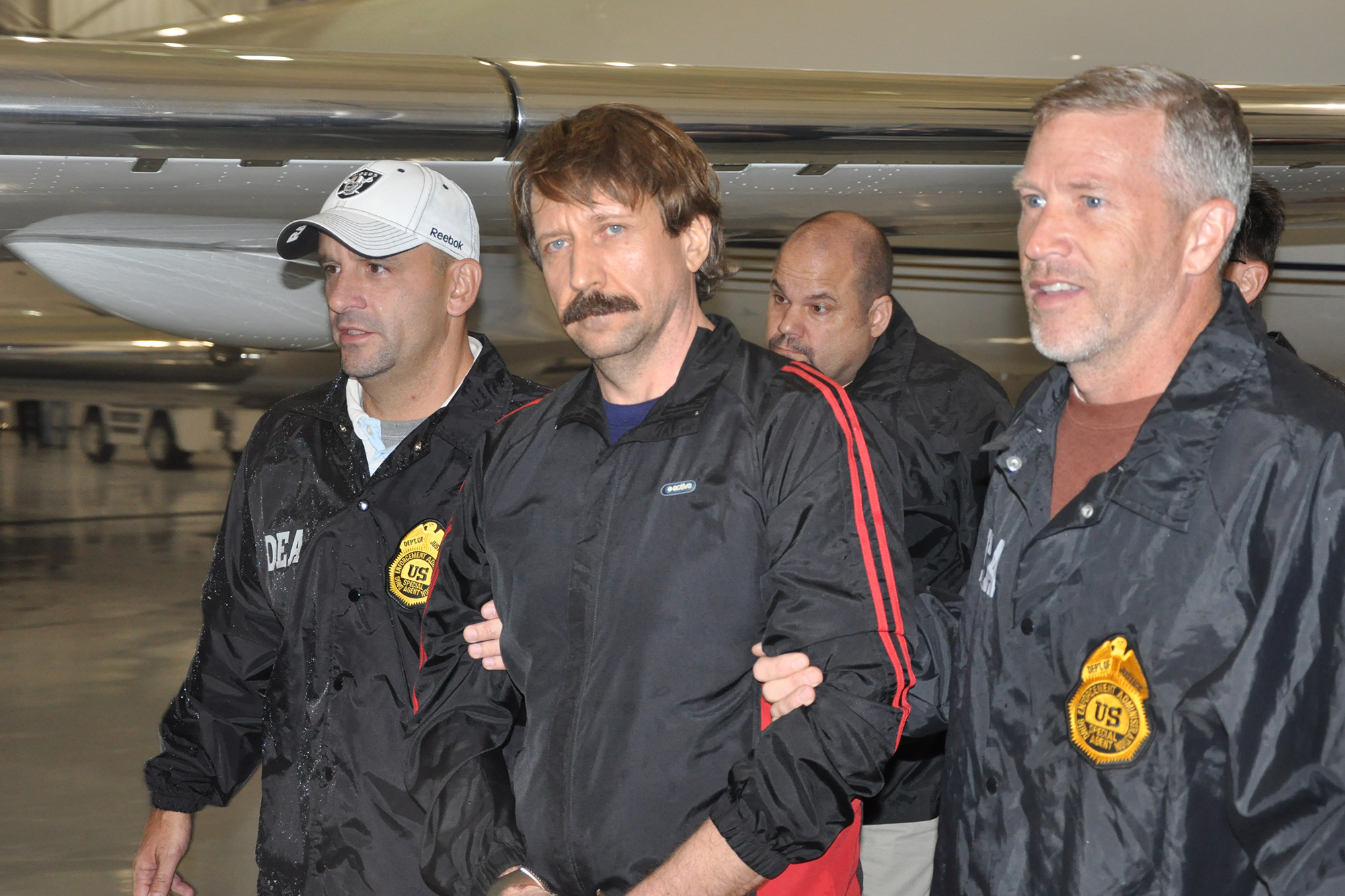 In this photo provided by the US Department of Justice, former Soviet military officer and arms trafficking suspect Viktor Bout, center — who has since been convicted and is serving a 25-year US prison sentence — deplanes after arriving at Westchester County Airport in White Plains, New York, in November 2010.