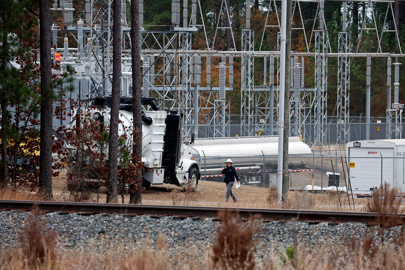 Workers work on equipment at the West End Substation in West End, North Carolina, on Monday, December 5.