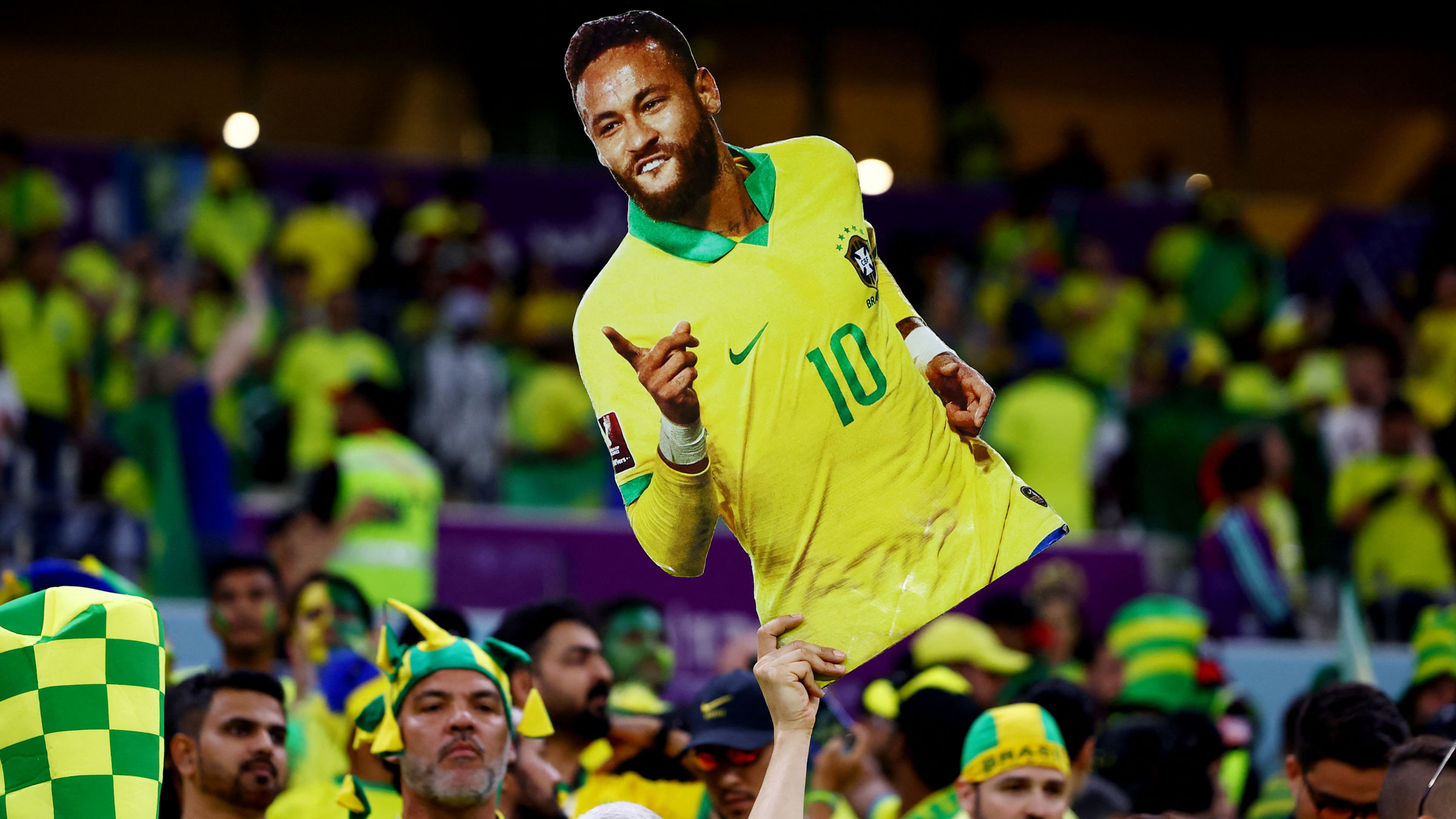 A Brazil fan displays a cardboard cutout of Neymar before the Serbia match.