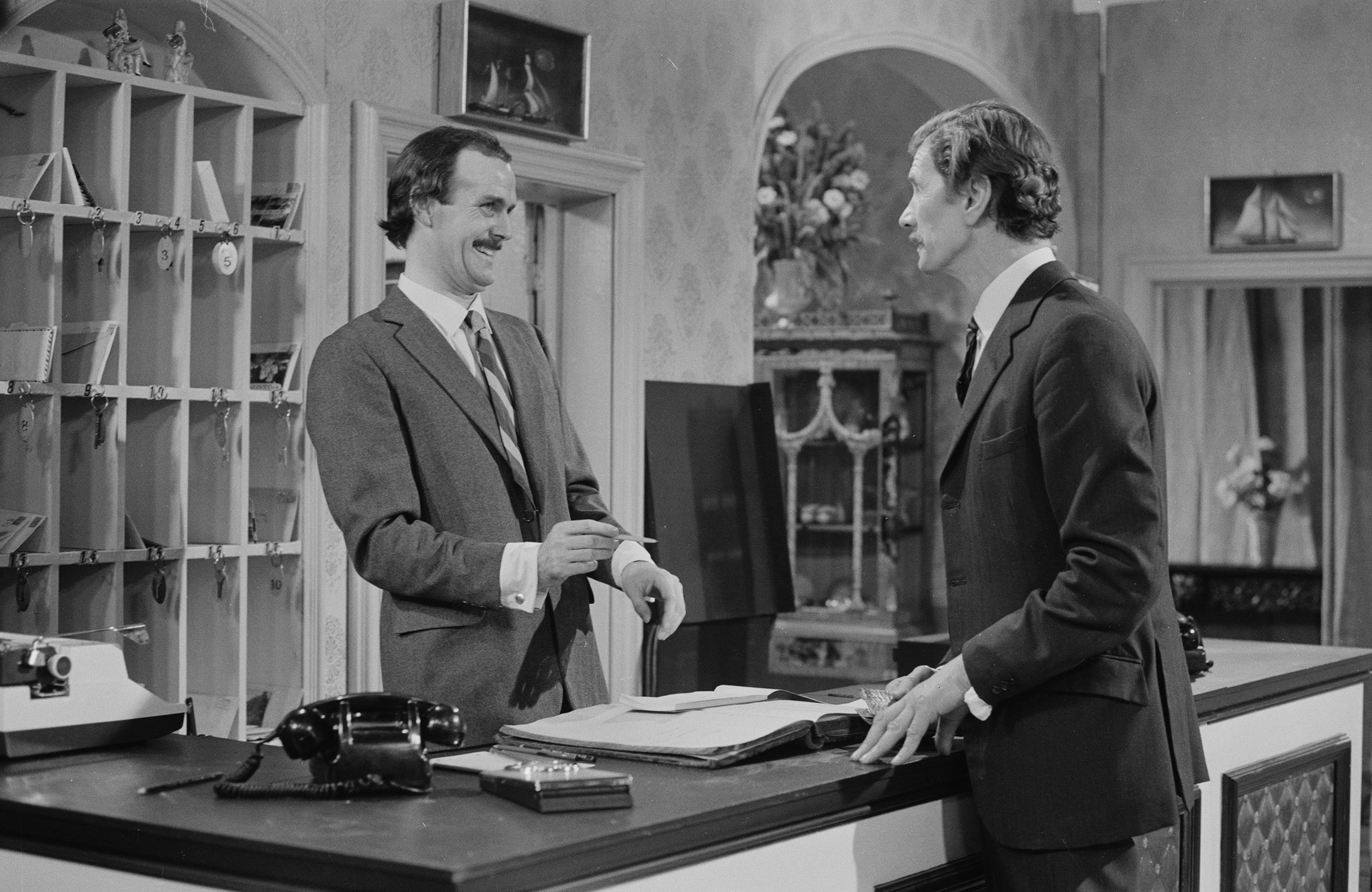 Actors John Cleese (left) and Michael Gwynn in a scene from "Fawlty Towers," broadcast on December 23, 1974. 
