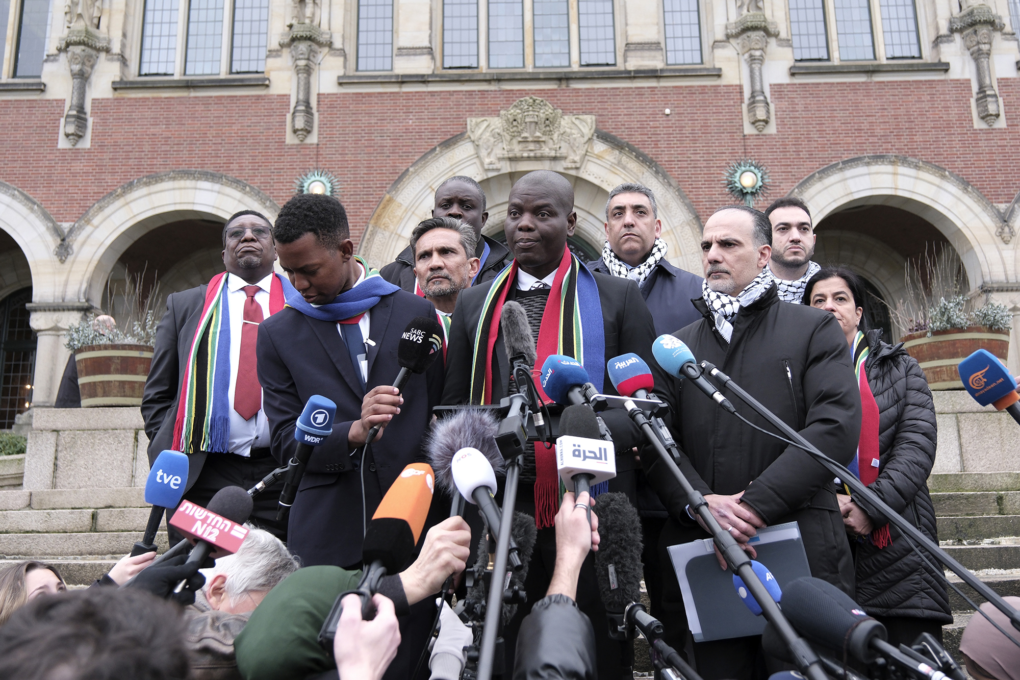 South Africa's Minister of Justice and Correctional Services Ronald Lamola, center, and Palestinian assistant Minister of Multilateral Affairs Ammar Hijazi, third right, address the media outside the International Court of Justice in The Hague, Netherlands, on January 11.