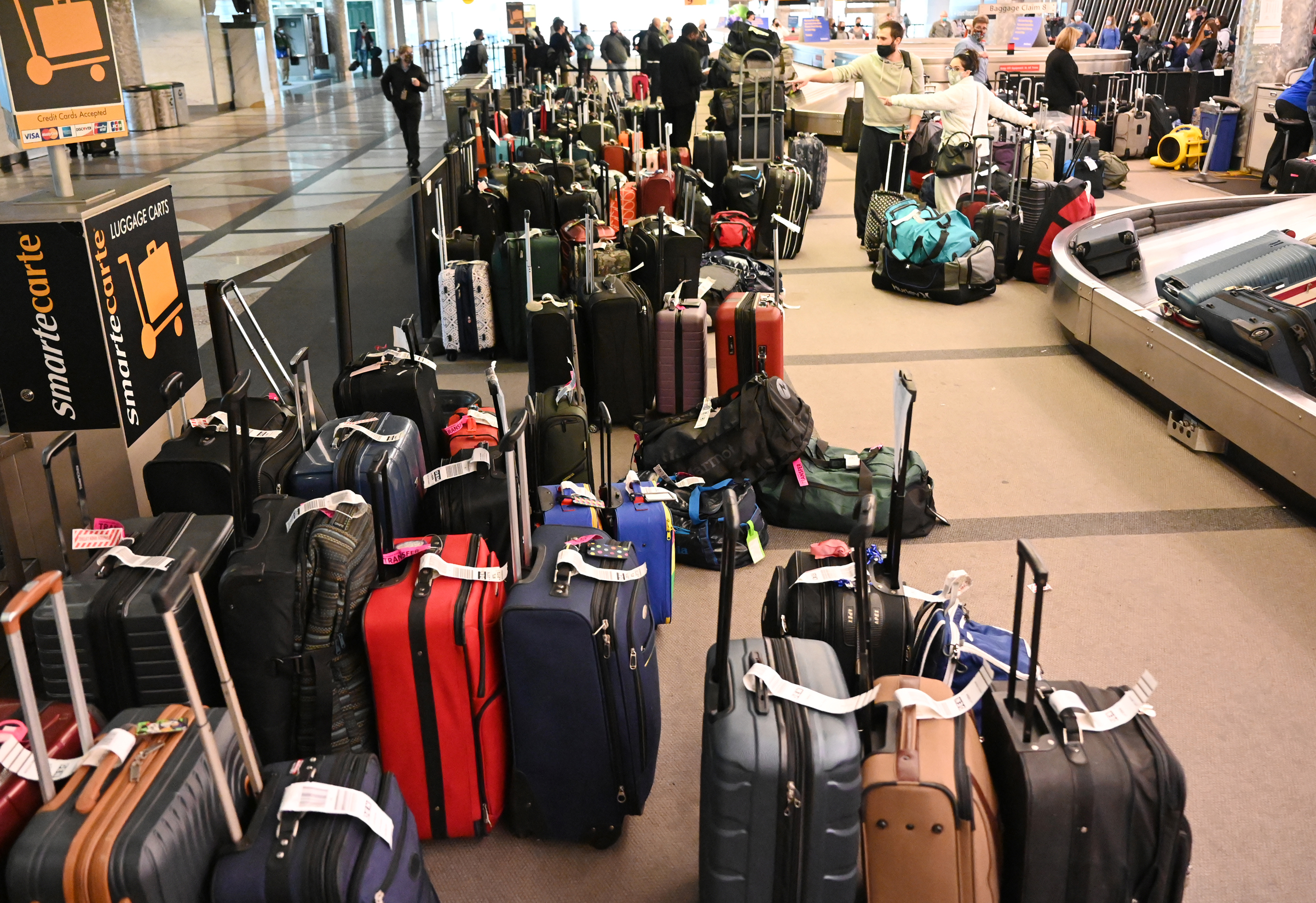 Unclaimed baggage starts to pile up outside the Southwest Airlines baggage claim at Denver International Airport on Monday, January 3.
