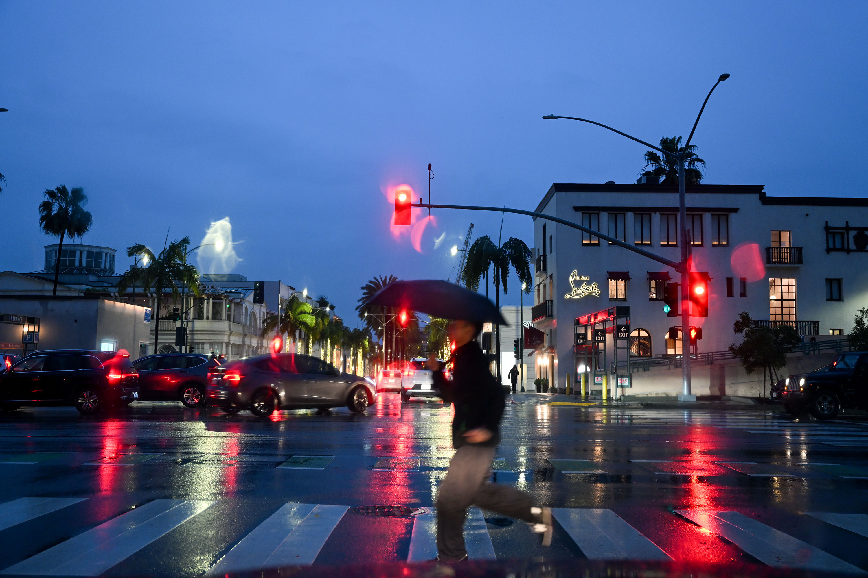 A person walks with an umbrella on Rodeo Drive in Beverly Hills, as atmospheric river storms hit Los Angeles, California, on February 5. 