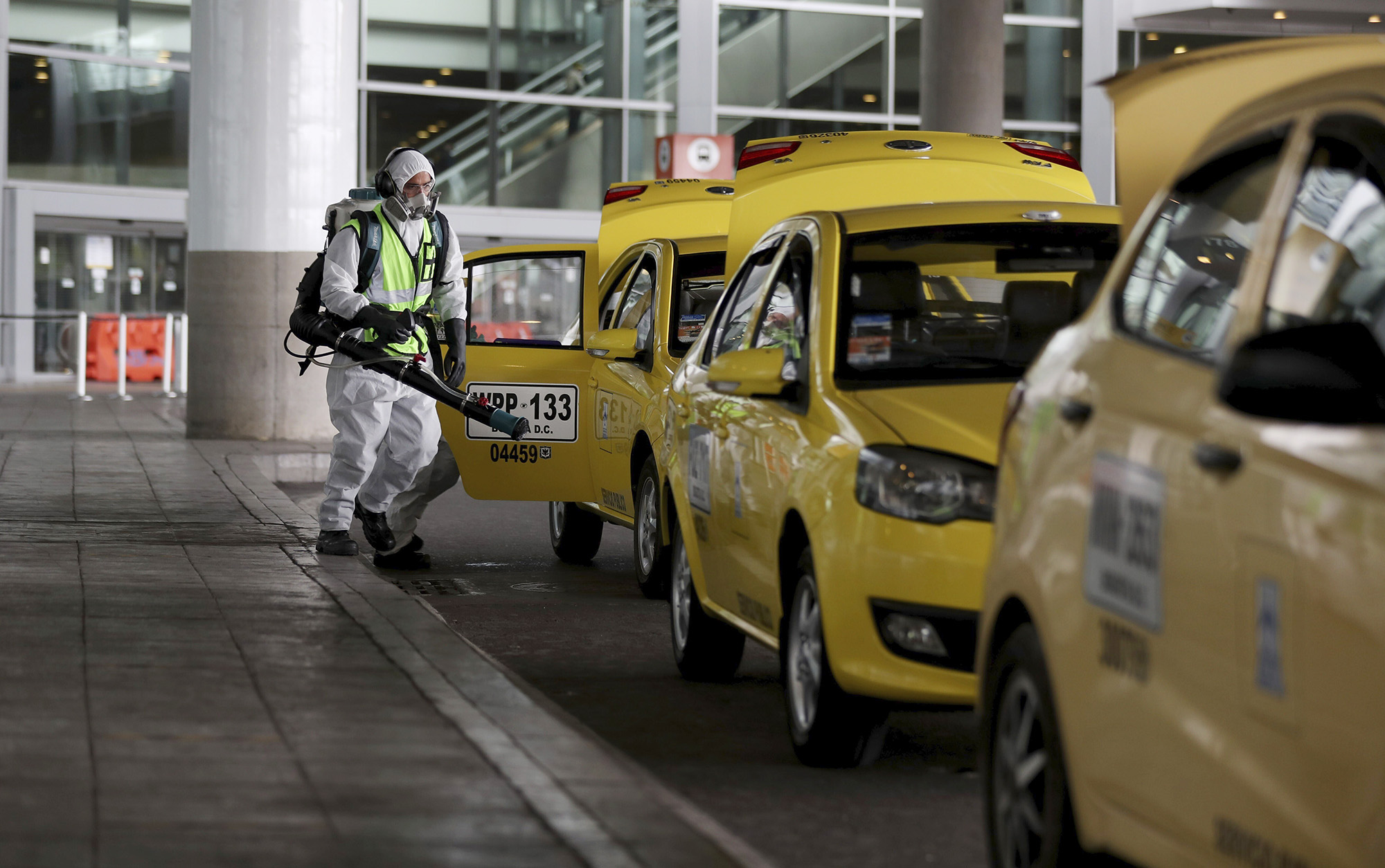 A worker disinfects taxis outside the El Dorado airport in Bogota, Colombia, on June 25. 