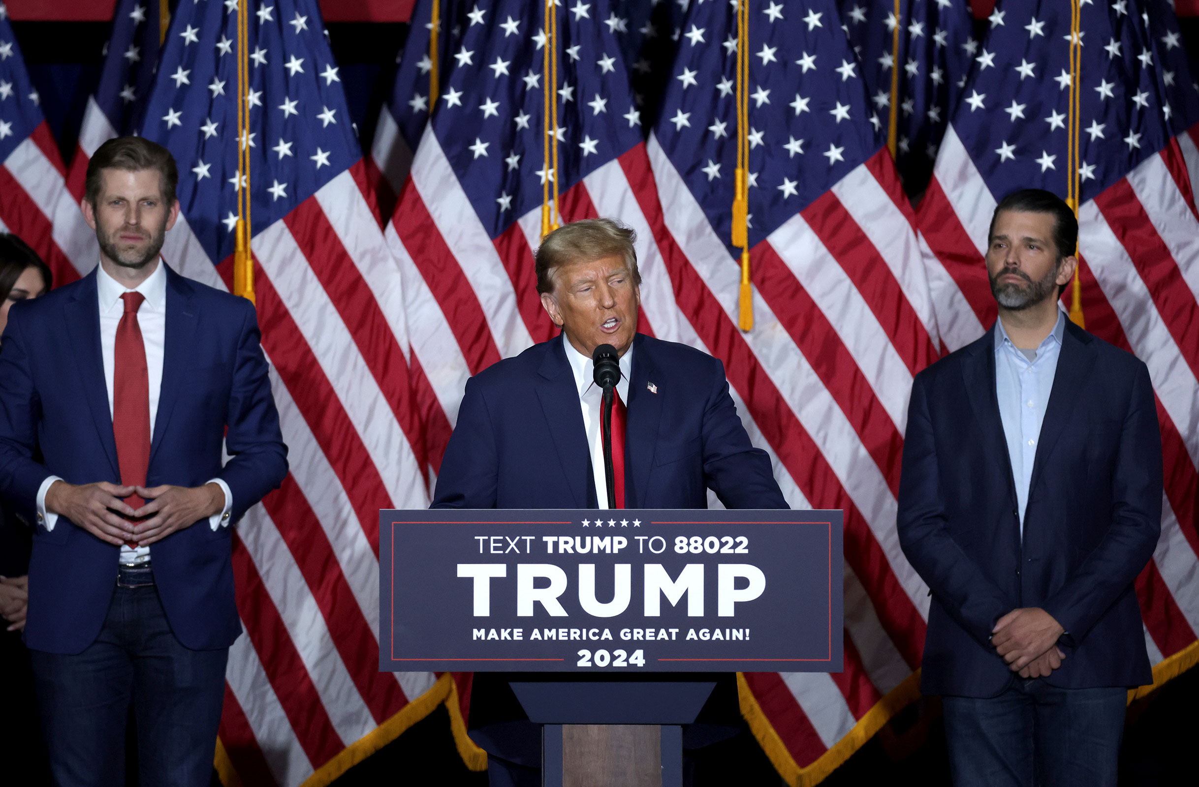 Former President Donald Trump speaks at his caucus night event, with sons Eric Trump and Donald Trump Jr. beside him, at the Iowa Events Center on January 15, in Des Moines, Iowa. 