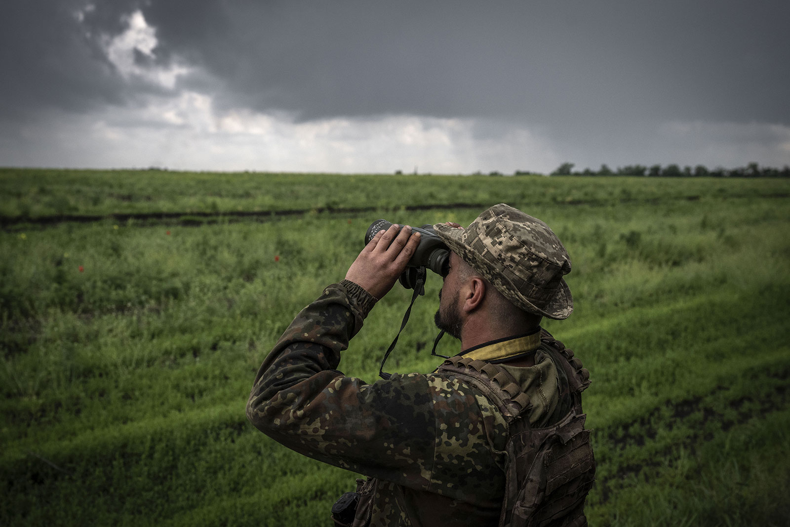 A Ukrainian soldier scouts the area with binoculars on the frontline in Donetsk Oblast, Ukraine on May 29. 