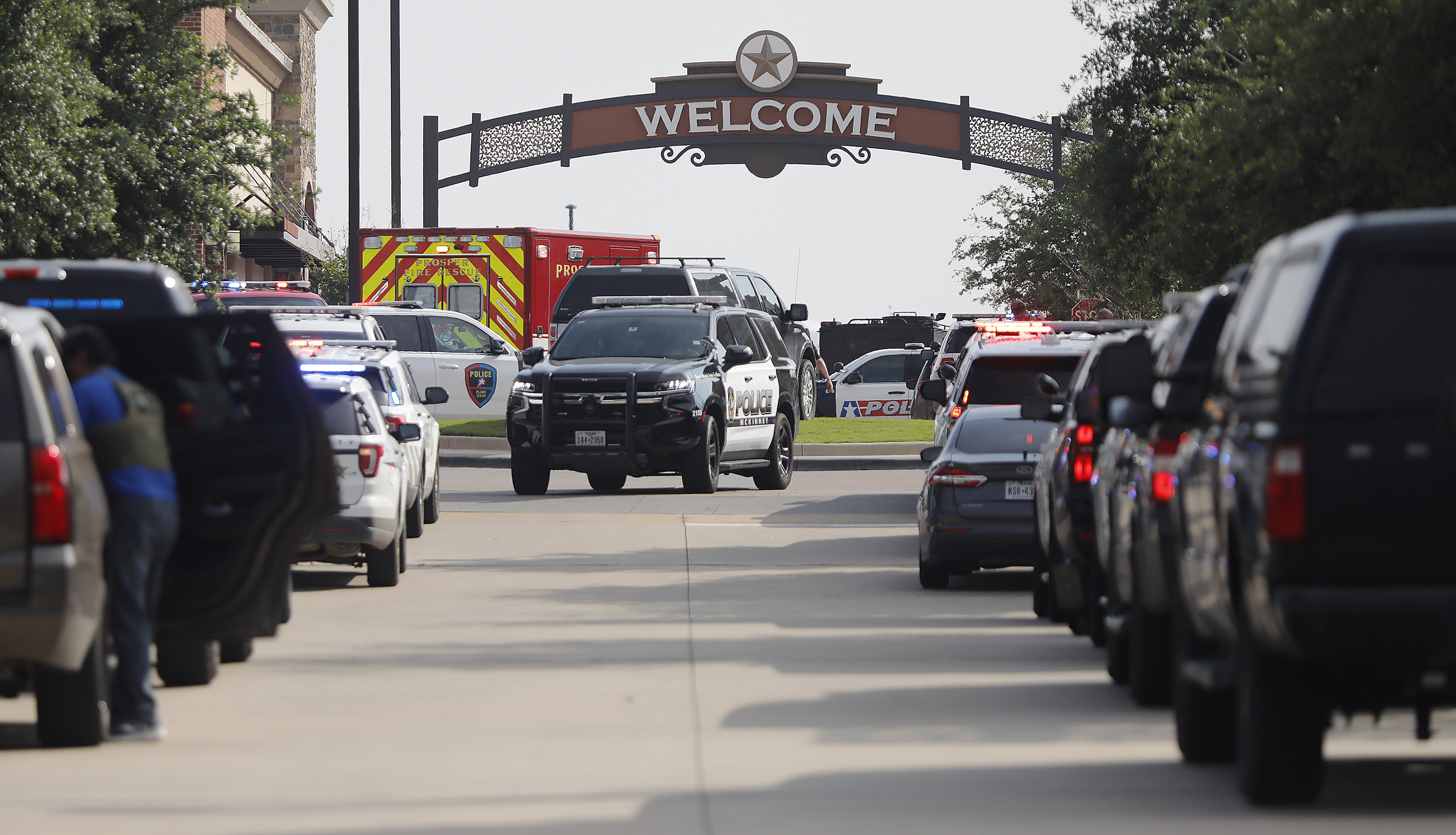 Emergency vehicles line the entrance to the Allen Premium Outlets where a shooting took place on Saturday in Allen, Texas.