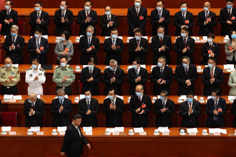 Delegates applaud as Chinese President Xi Jinping arrives for the opening session of China's National People's Congress at the Great Hall of the People in Beijing on Friday.
