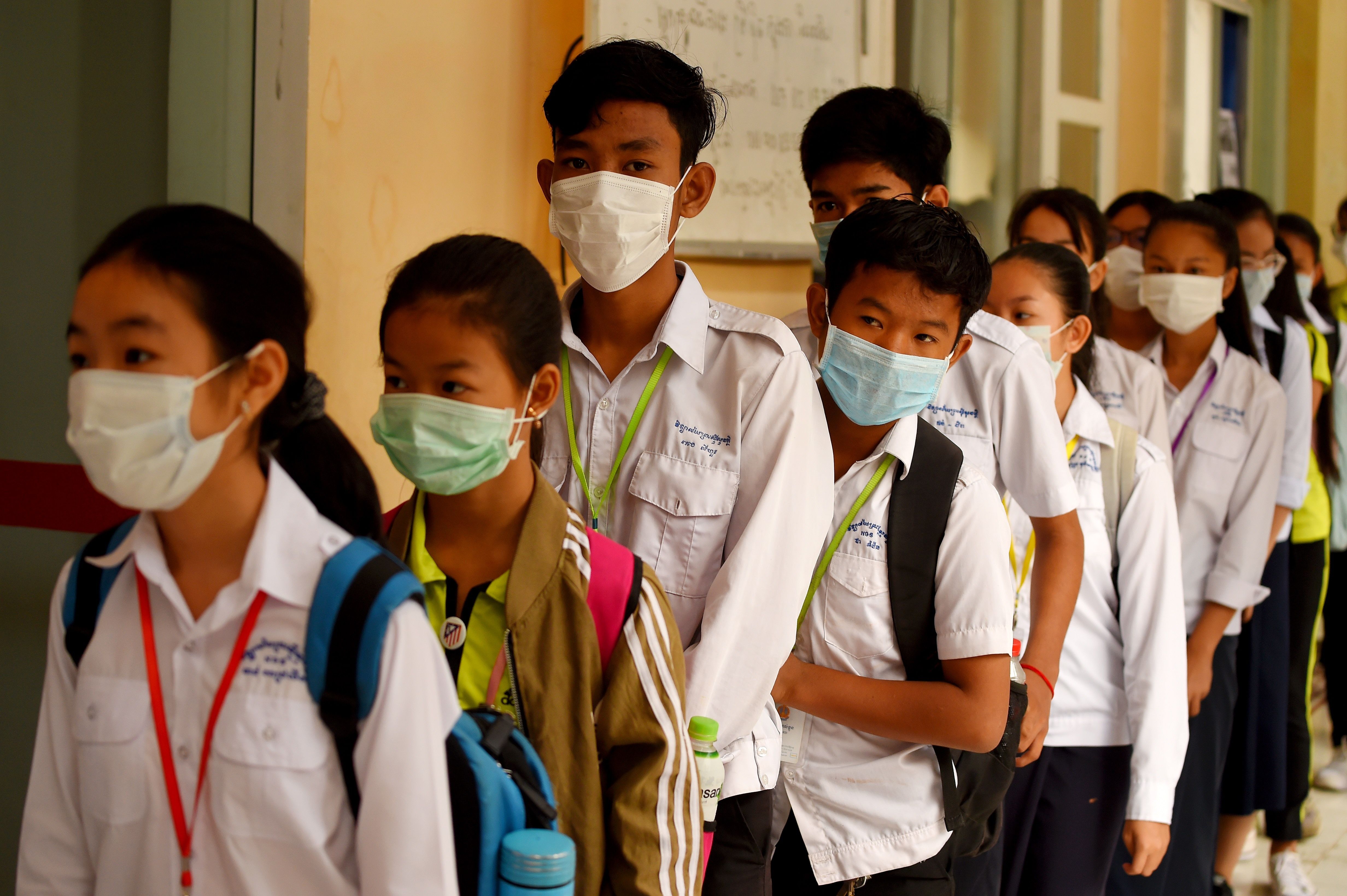 Students line up to disinfect their hands before entering class in Phnom Penh, Cambodia, on January 28, 2020.