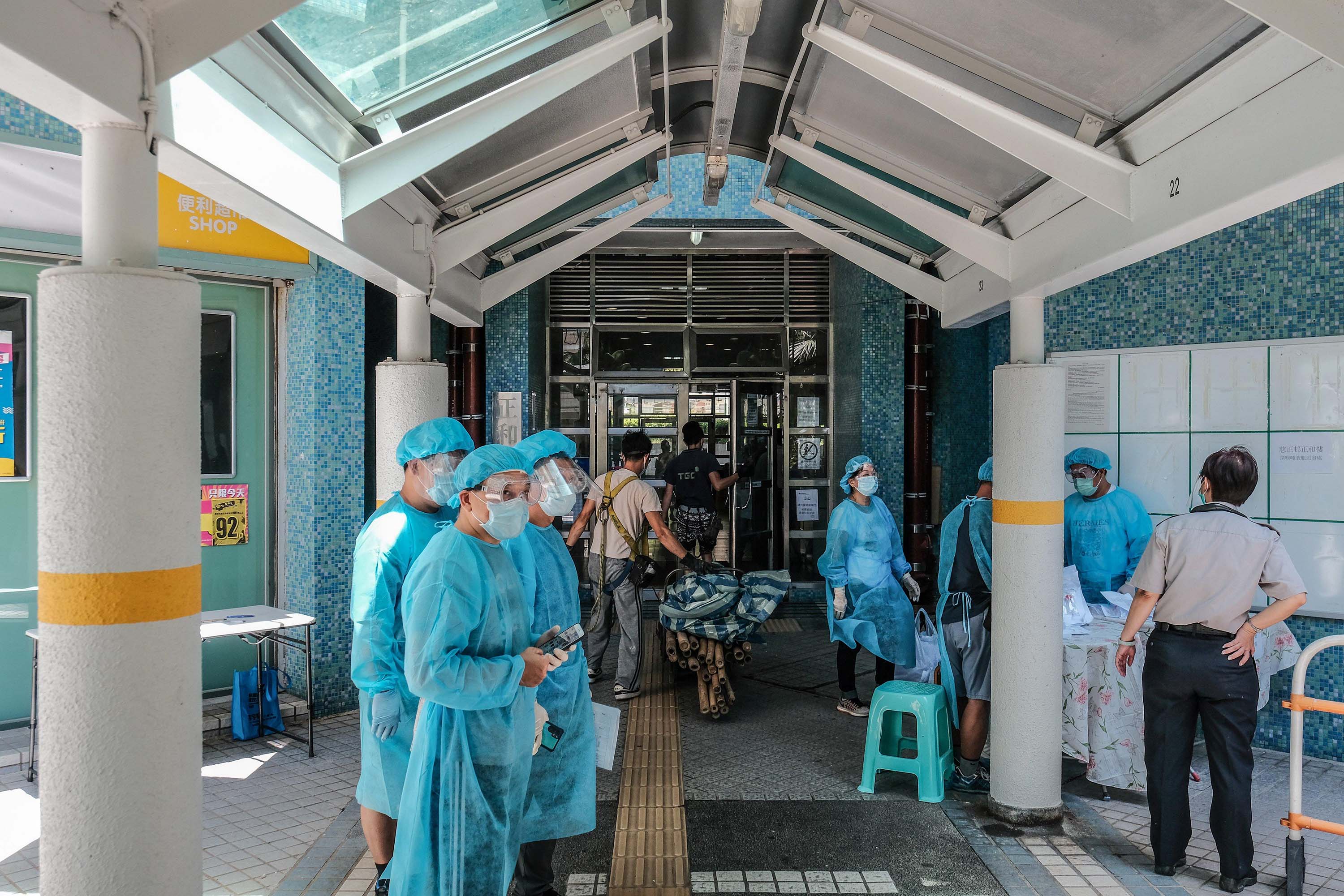 Medical workers hand out Covid-19 test kits to local residents at a residential block in Hong Kong on July 28.