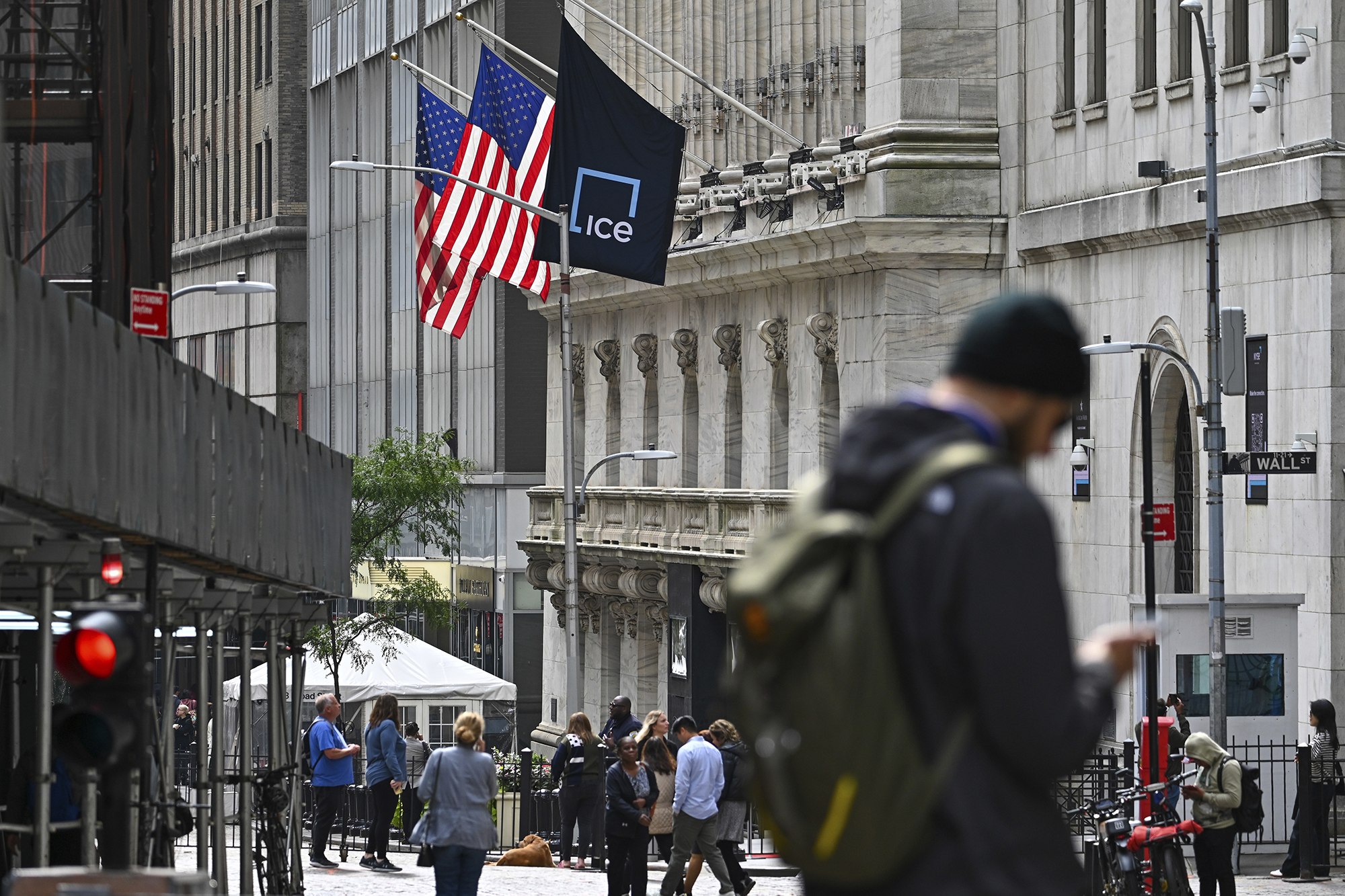 People walk past the New York Stock Exchange on Wall Street on September 27 in New York City.