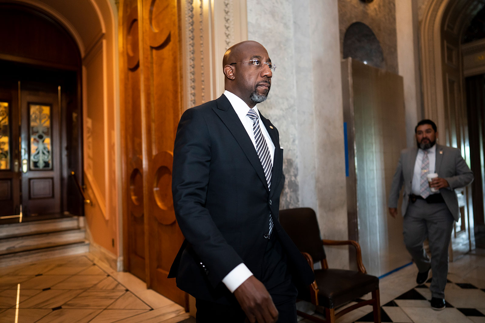 Sen. Raphael Warnock leaves the chamber before a procedural vote at the Capitol in Washington on May 11.
