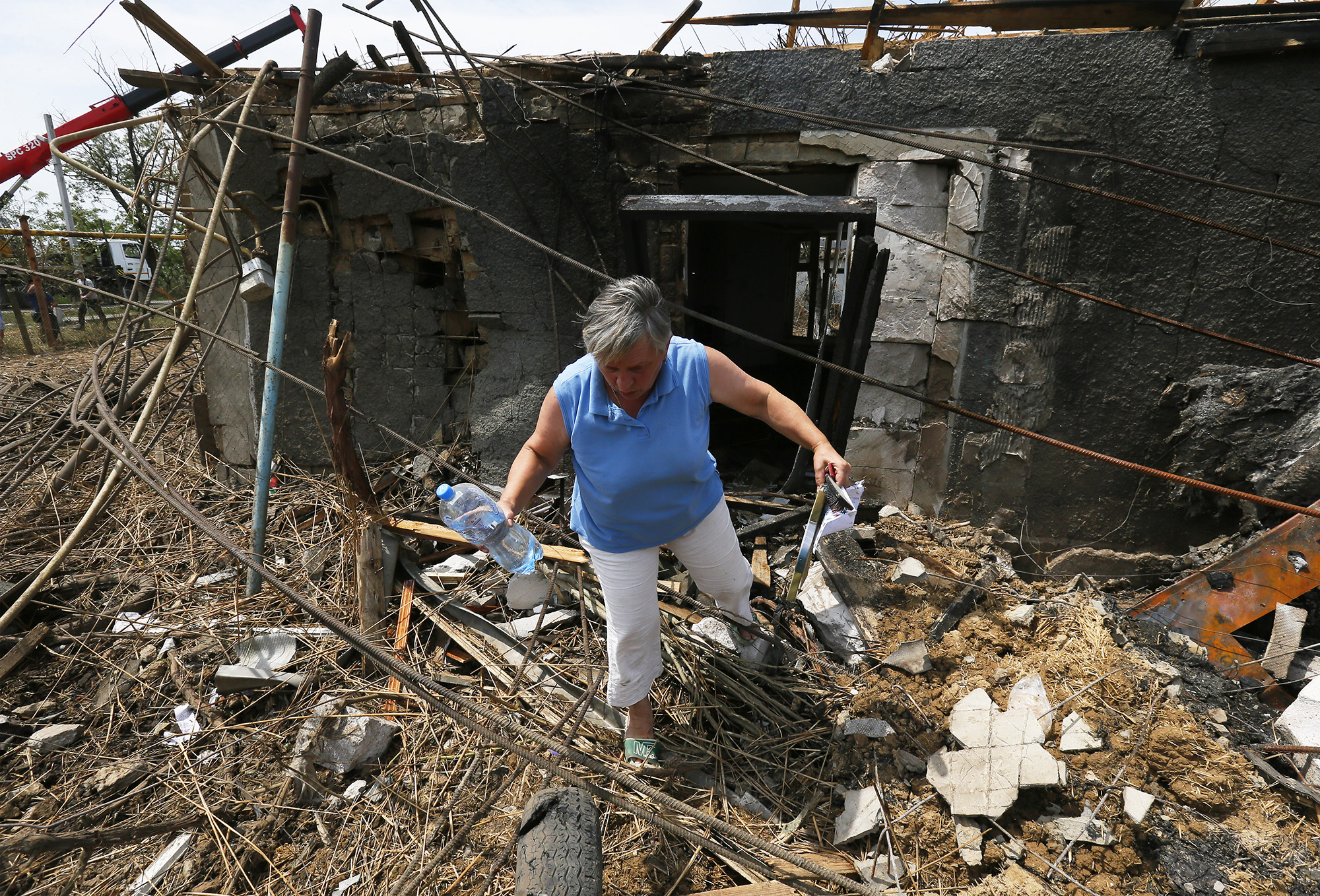 A woman walks next to her damaged house, caused by a rocket strike in the Odesa region, Ukraine, on 27 June.