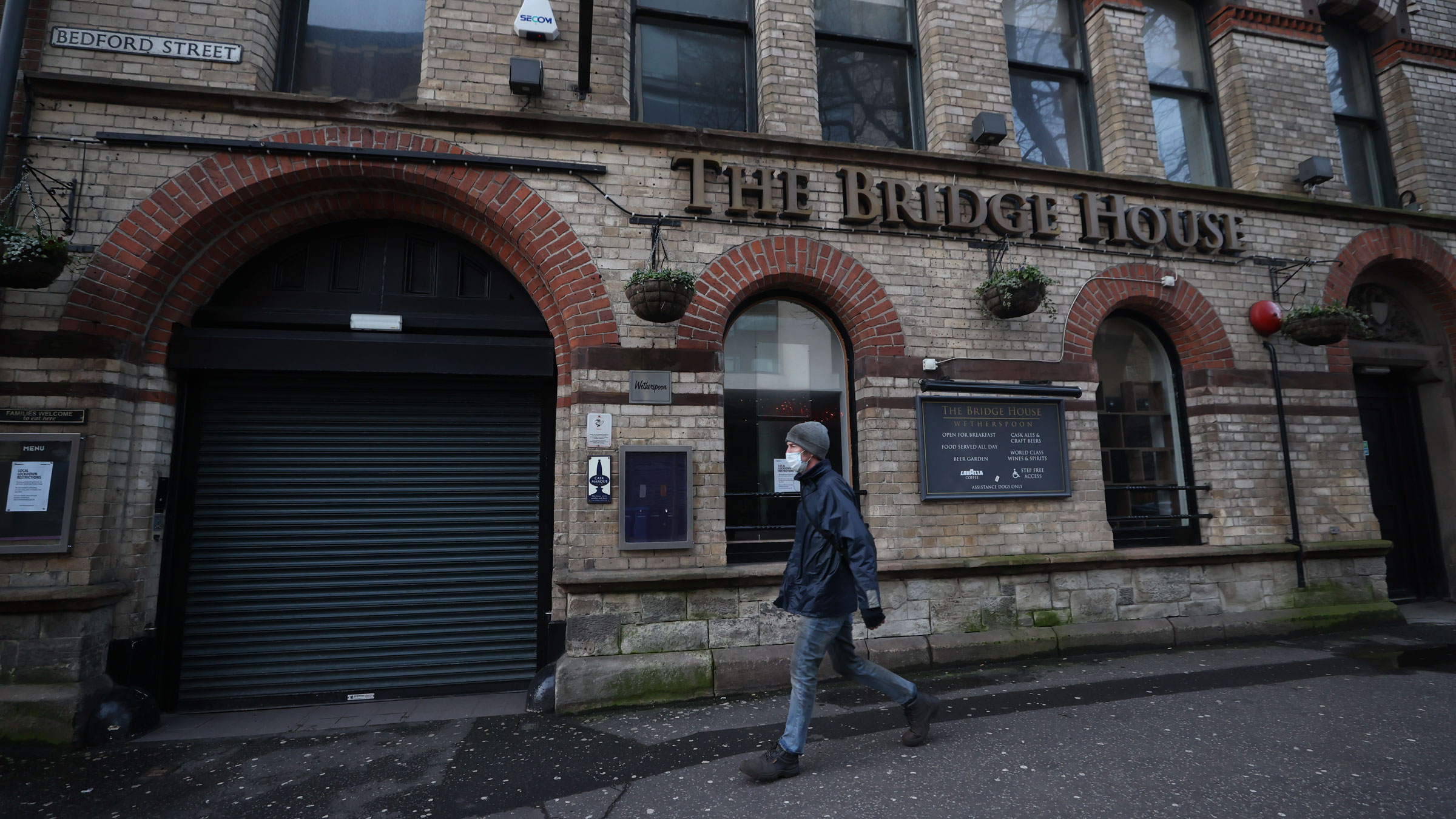 A man walks past a shuttered pub in Belfast, Northern Ireland, on Monday.
