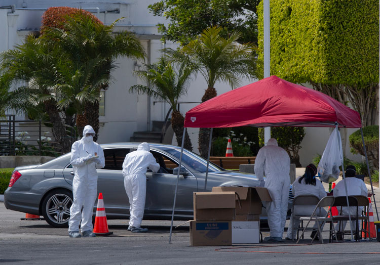 Los Angeles residents are administered with a test for the coronavirus while in their vehicles inside the Crenshaw Christian Center in South Los Angeles Wednesday, March 25.