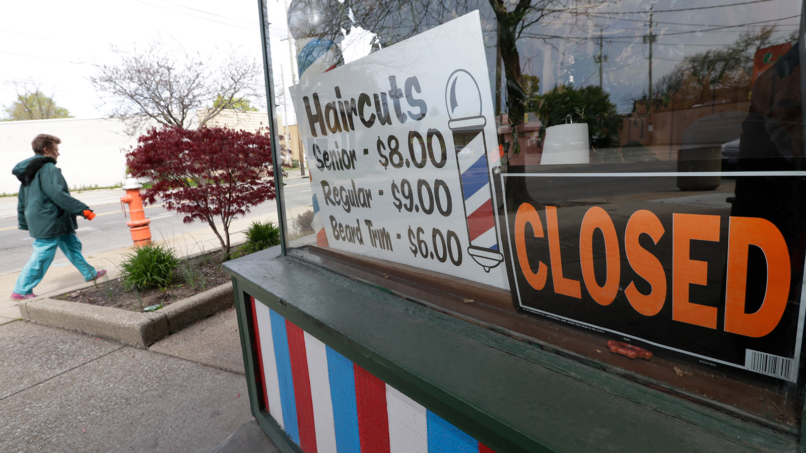 A woman walks past a closed barber shop in Cleveland on May 6.
