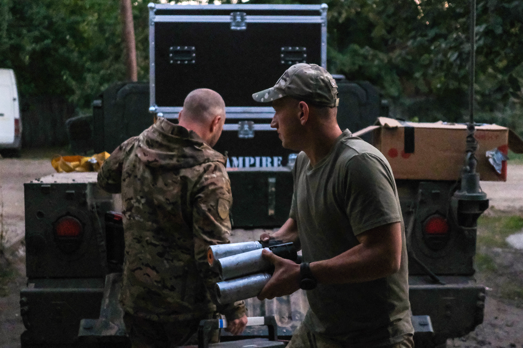 Ukrainian soldiers load drones and ammunition into the back of a US-donated Humvee before a night-time assault.