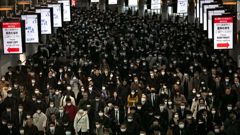 A large crowd wearing masks commutes through Shinagawa Station in Tokyo on Tuesday.