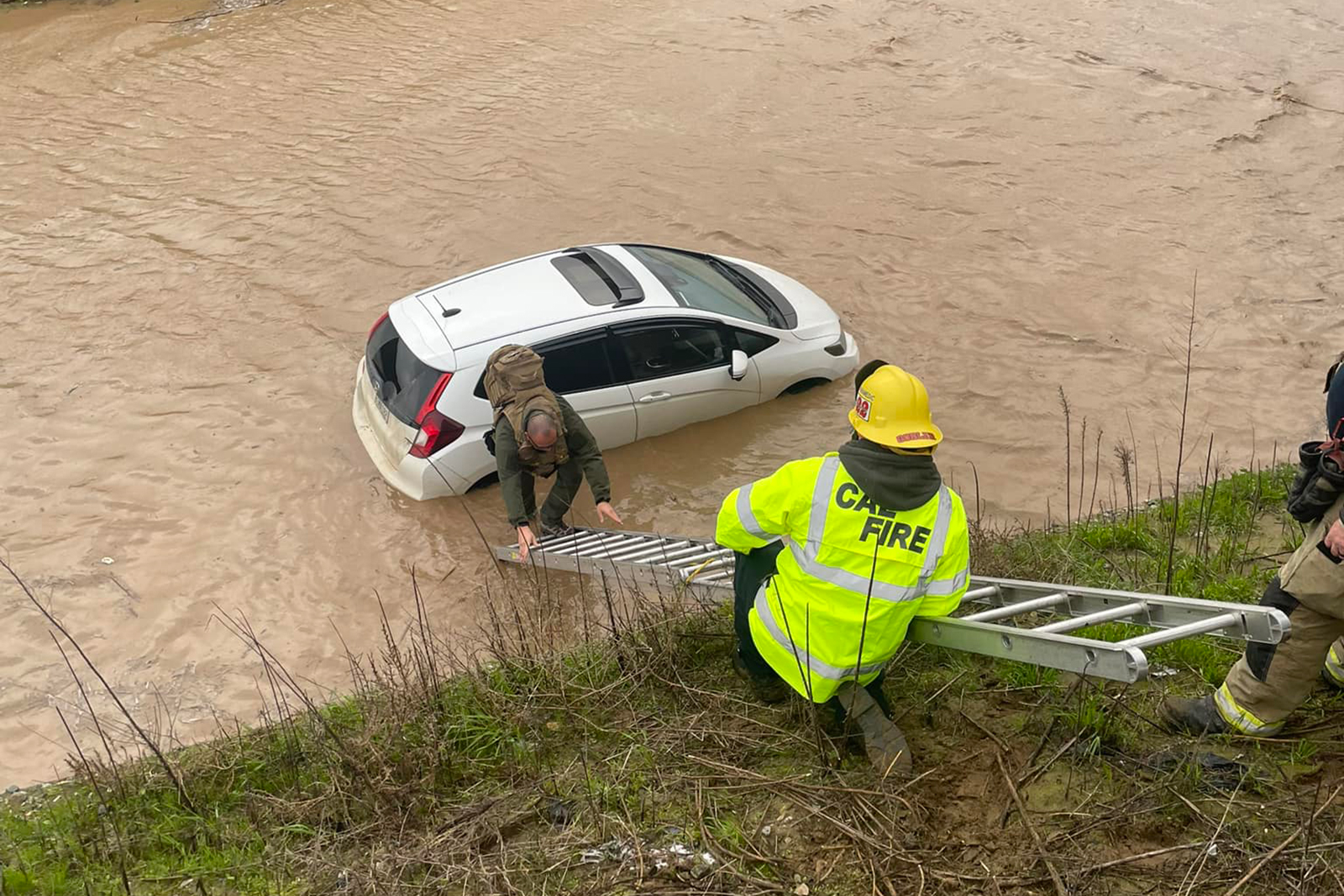 Firefighters rescue a man caught in high waters in Nipomo, central California, on Sunday.