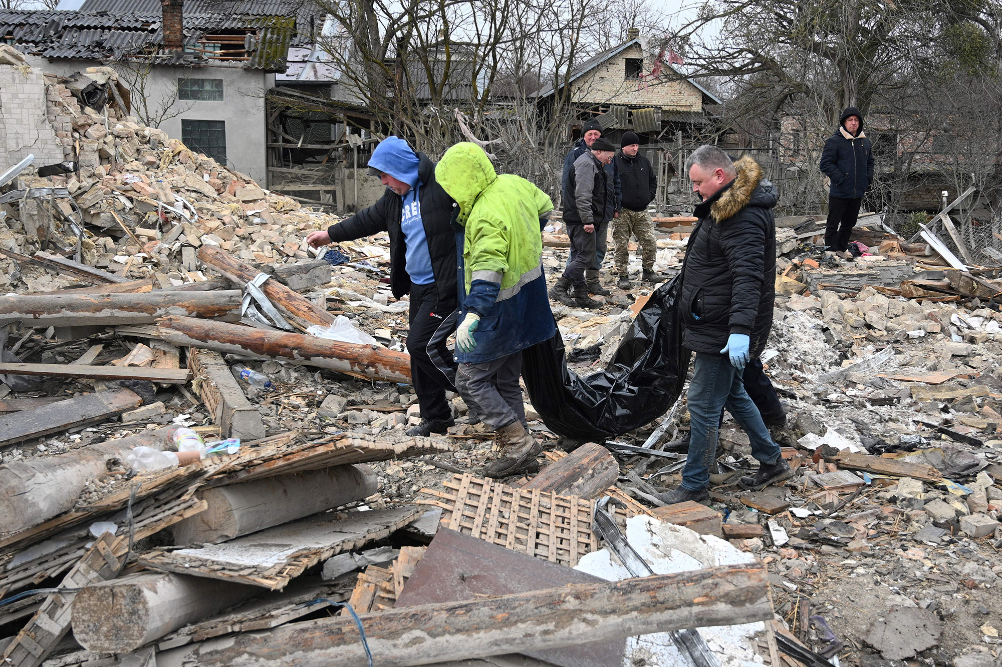 Police experts and local residents carry an unidentified body following a Russian strike in the village of Velyka Vilshanytsia, Lviv region, Ukraine, on March 9.