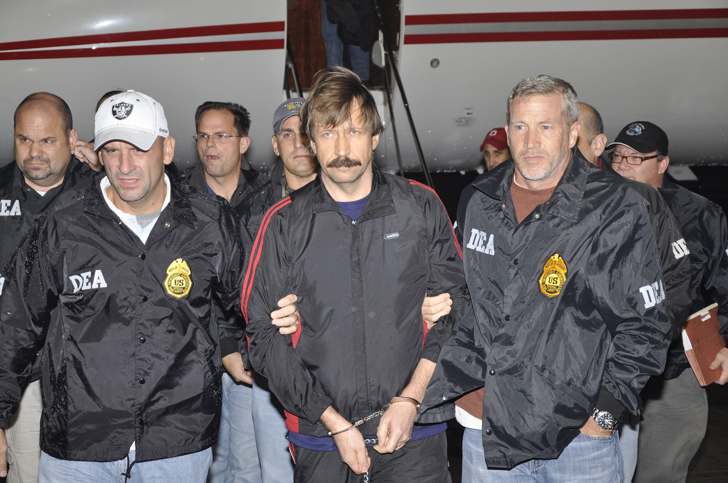 In this photo provided by the U.S. Department of Justice, former Soviet military officer and arms trafficking suspect Viktor Bout, center, deplanes after arriving at Westchester County Airport November 16, 2010 in White Plains, New York. 